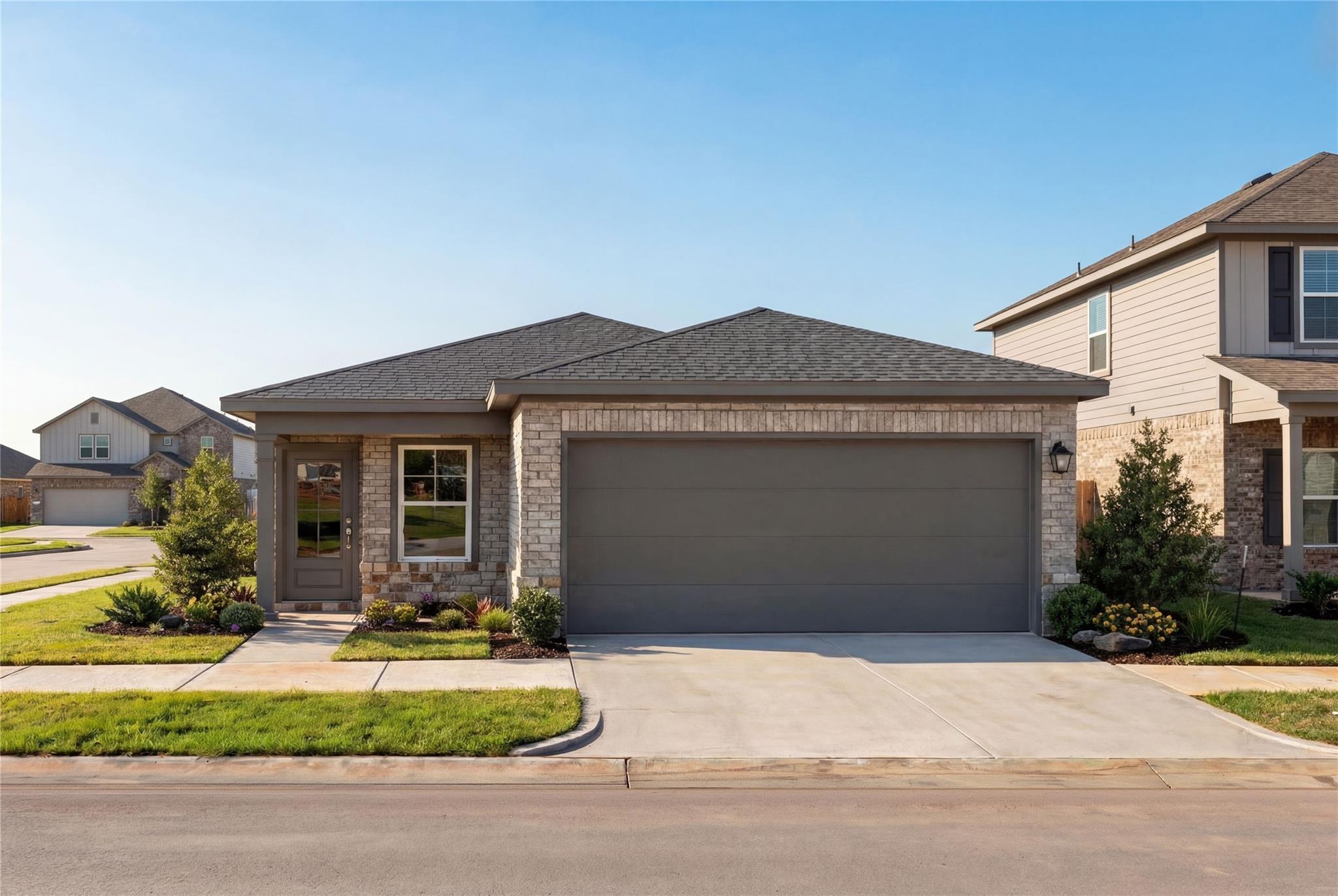 Modern 4-bedroom single-story brick home with stone accents, 2-car garage, and landscaped yard in Emberly, Beasley, Texas