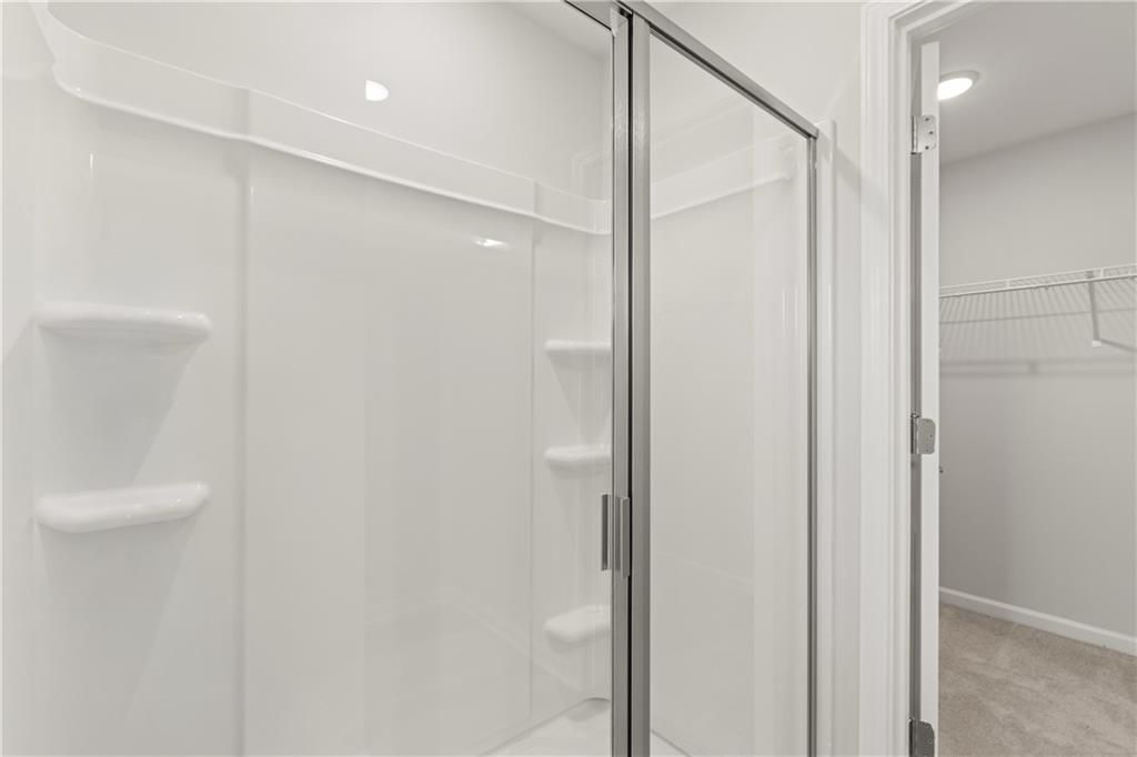 Walk-in shower with glass door and adjacent walk-in closet in The Russell A floor plan at Cedar Farms, Winder, GA.