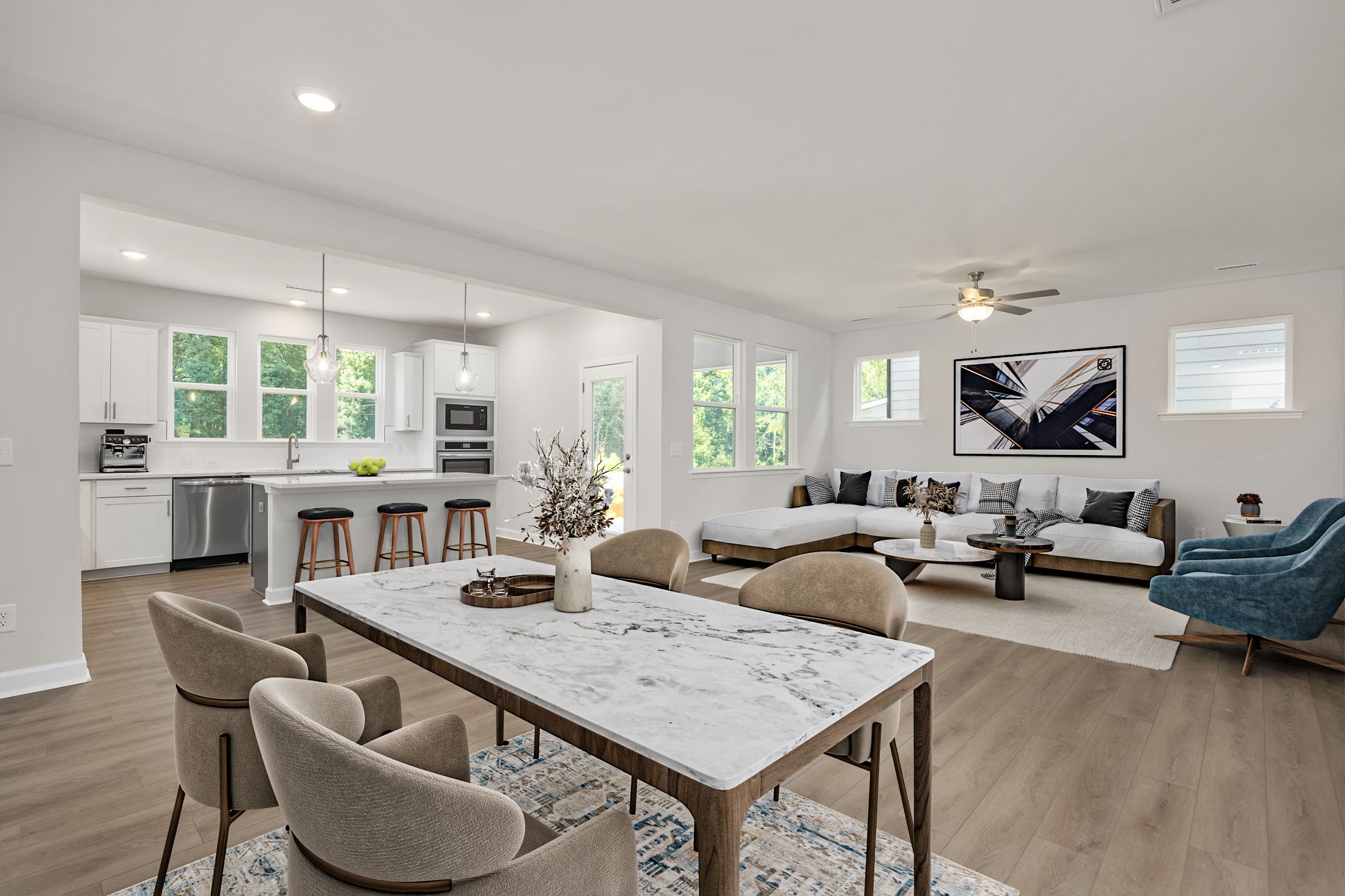 Open-concept kitchen dining living room in Ashland Apex NC by Davidson Homes featuring white cabinets marble island hardwood floors and neutral seating