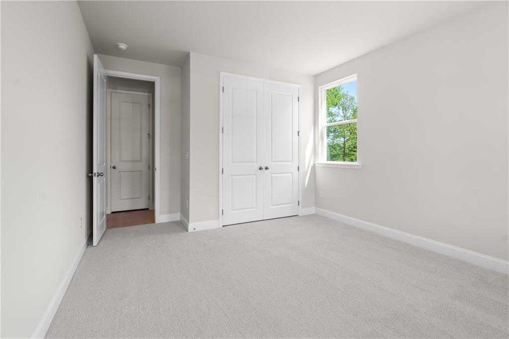 Spacious secondary bedroom with double closet doors and adjacent bath in Davidson Homes The Hickory B, Buford, GA