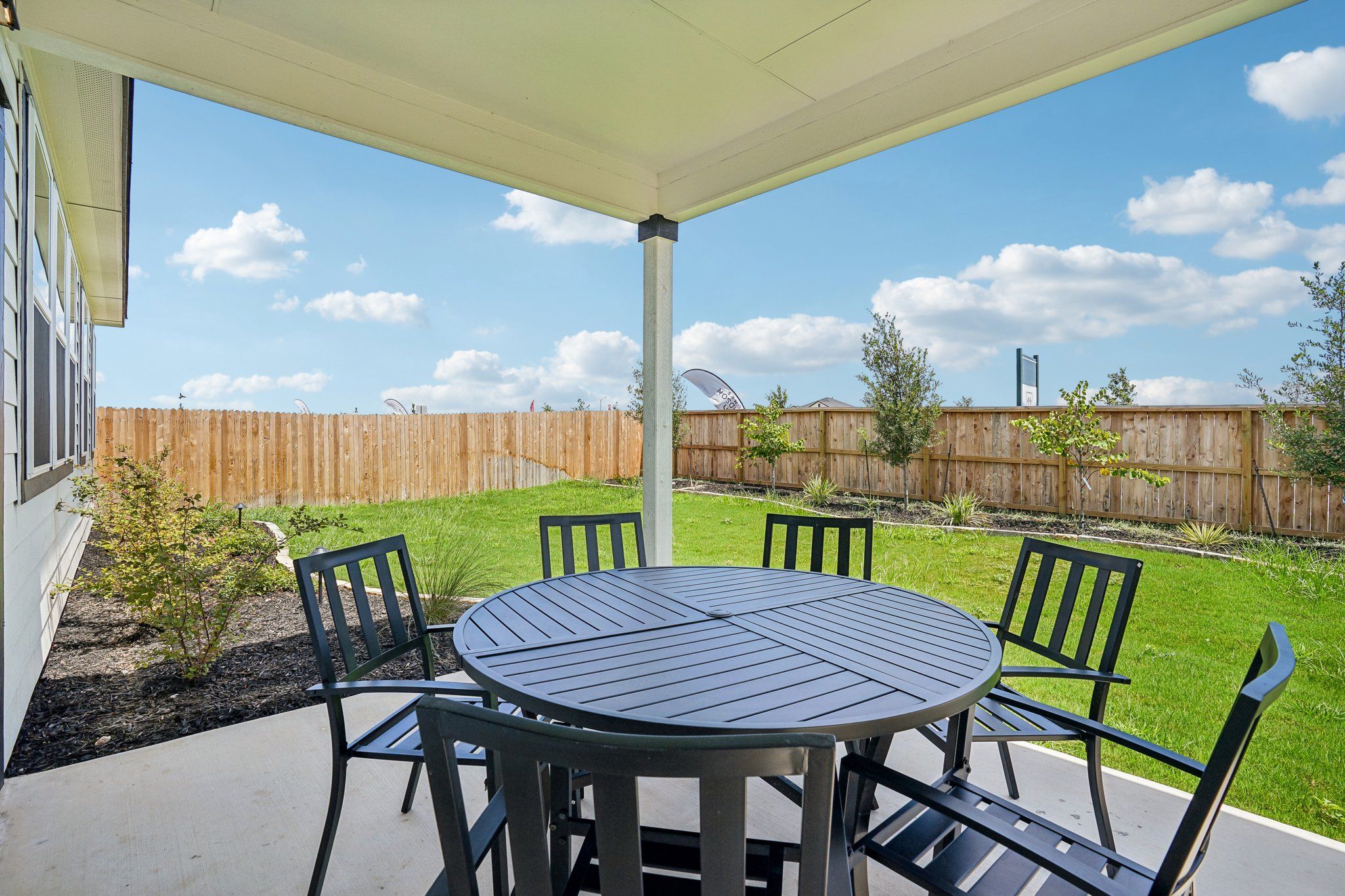 Covered patio with dining set at Morgan Meadows in San Antonio, Texas by Davidson Homes featuring a private backyard.