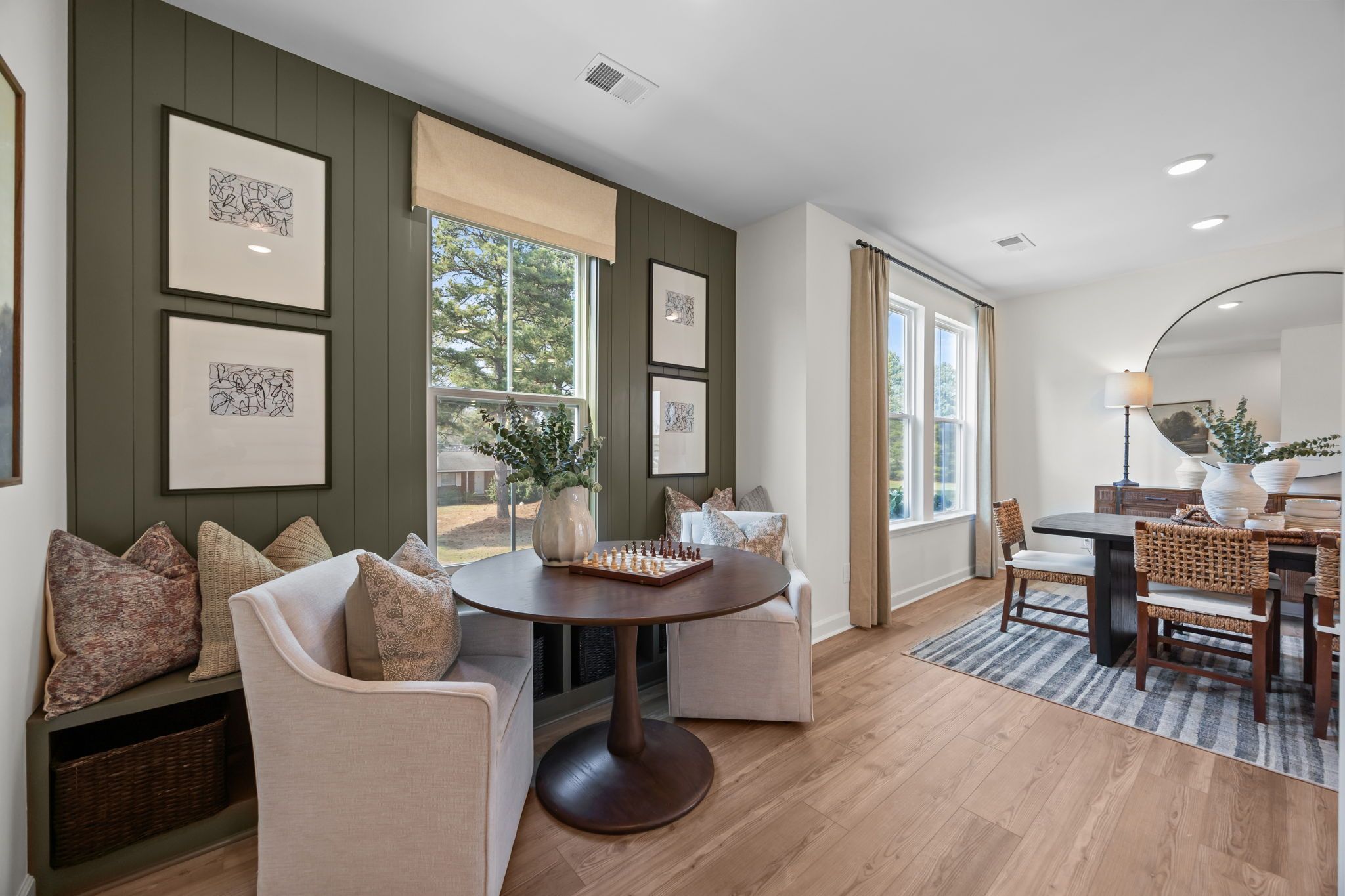 Elegant dining nook in Camden Park Knightdale NC by Davidson Homes with round game table, shiplap wall, and hardwood floors