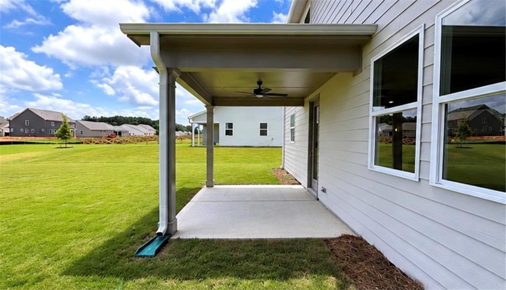 Covered back patio with ceiling fan at The Hickory C floor plan in Wehunt Meadows, Hoschton, Georgia.
