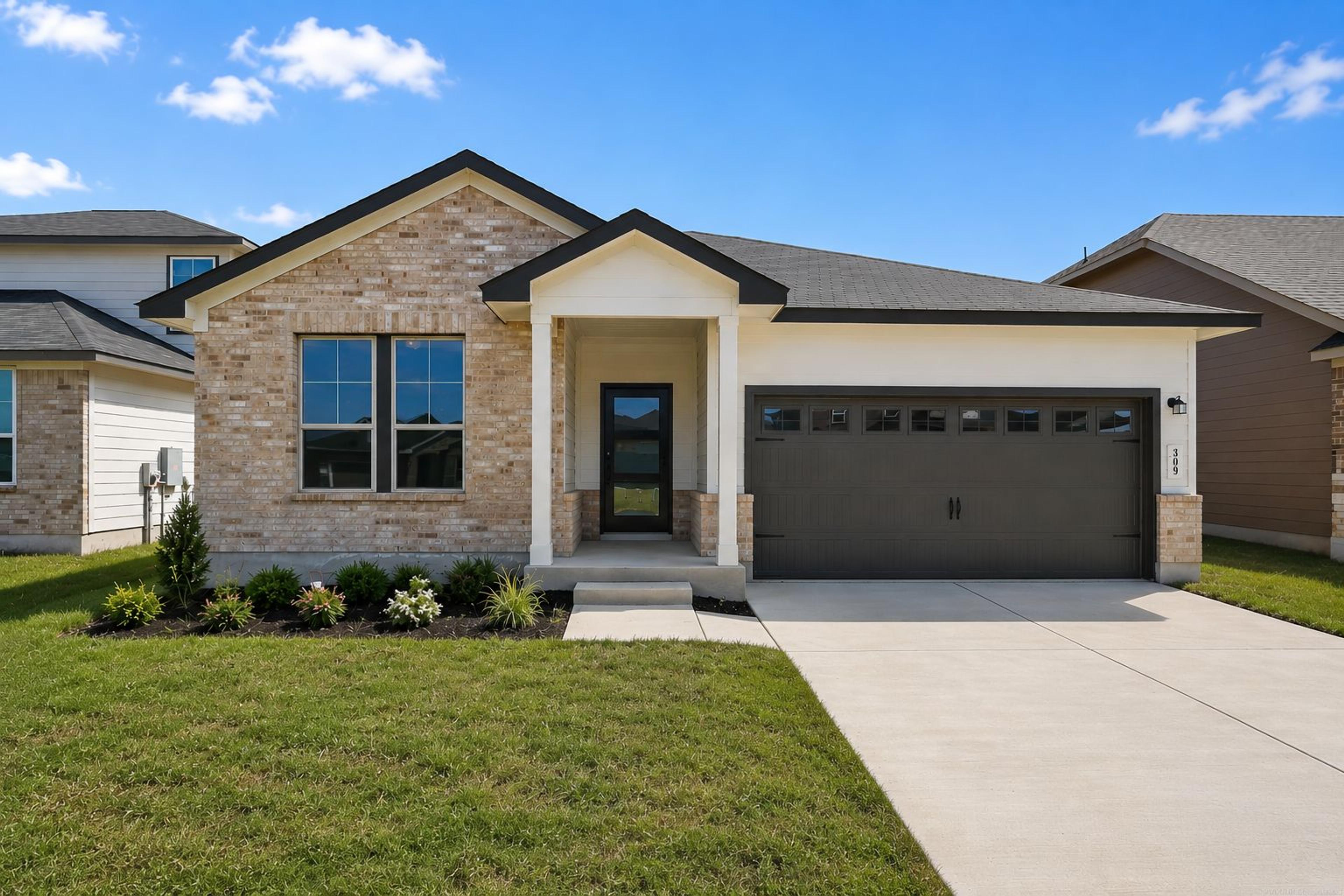 Modern kitchen with dark cabinets, granite island, stainless steel appliances at Hannah Heights in Seguin, Texas