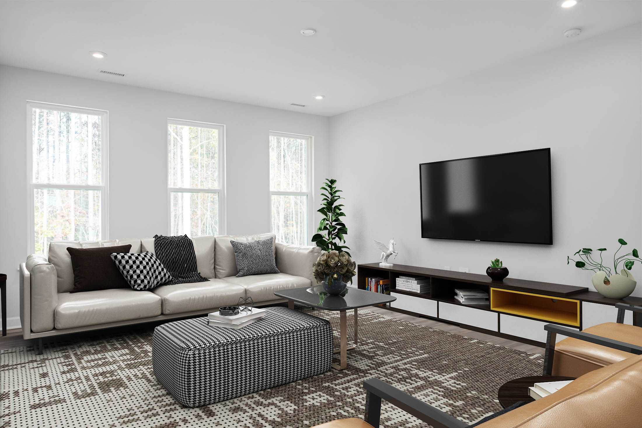 Contemporary living room at Stagecoach Corner in Mebane NC with gray L-shaped sofa, wall-mounted TV, indoor plants, and modern decor