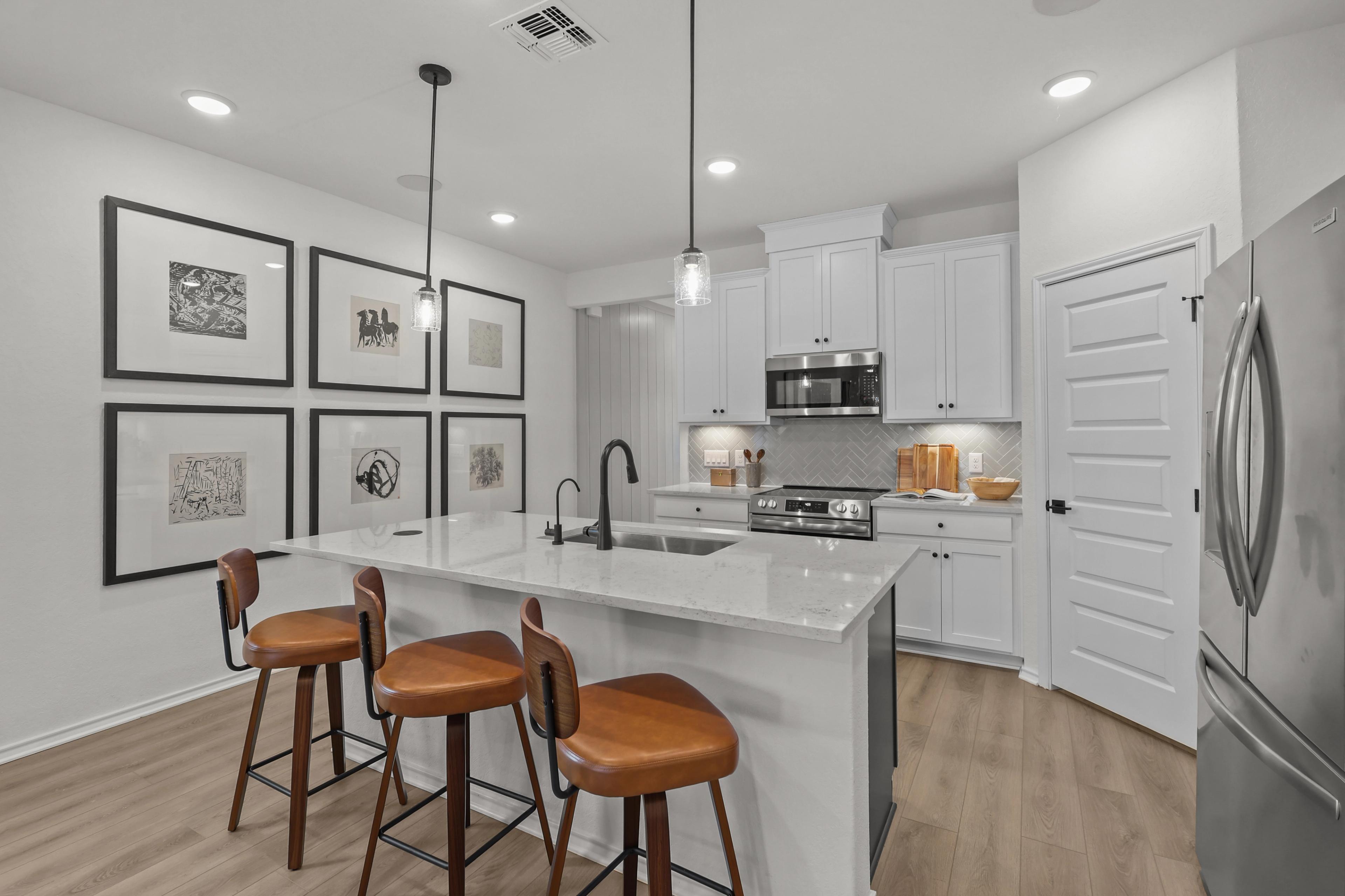 Open-concept kitchen with white cabinets and stainless appliances located in San Antonio, TX