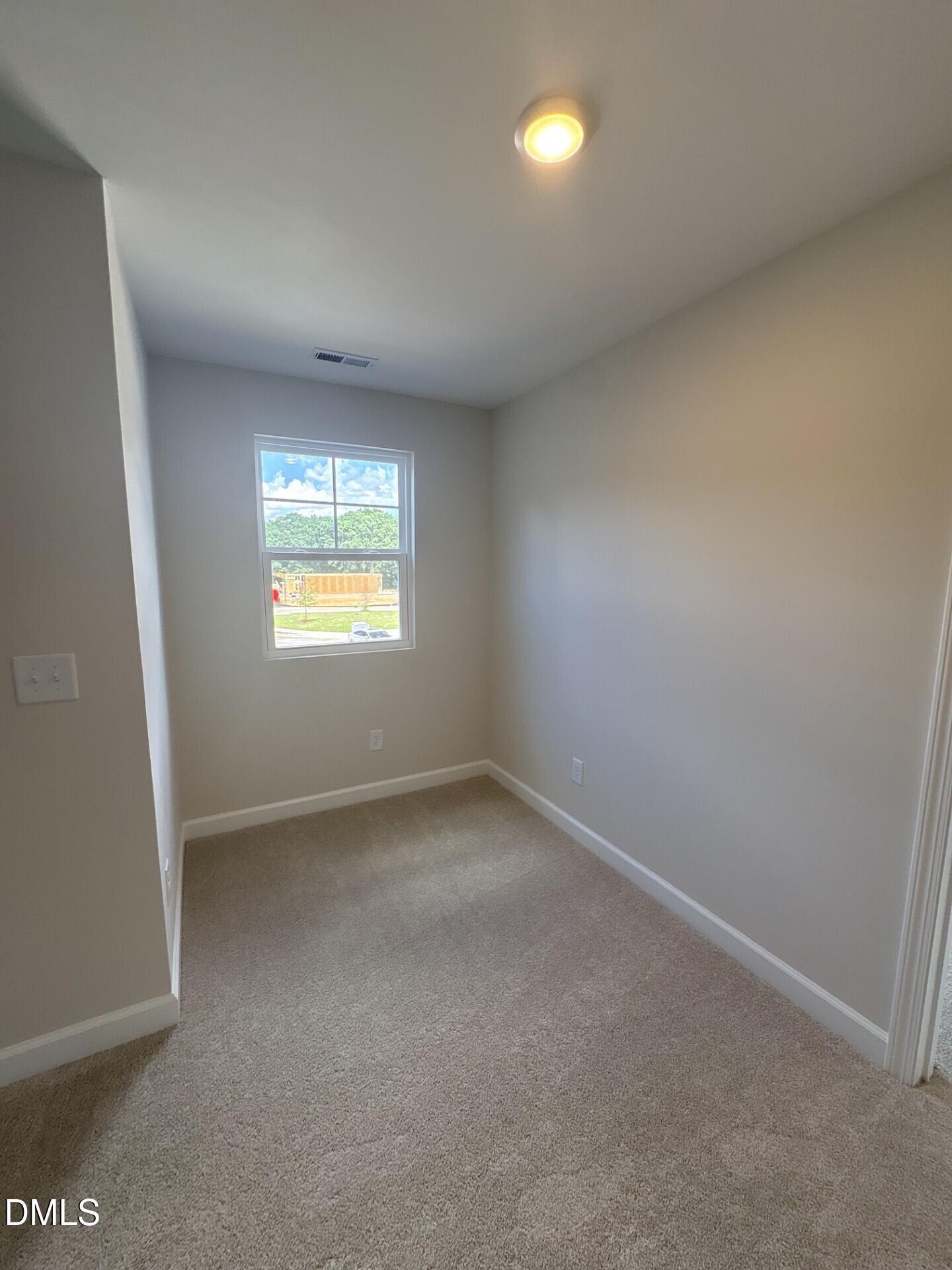Bright, carpeted bedroom with natural light in The Ash C floor plan at Woodland Crossing, Zebulon, North Carolina.