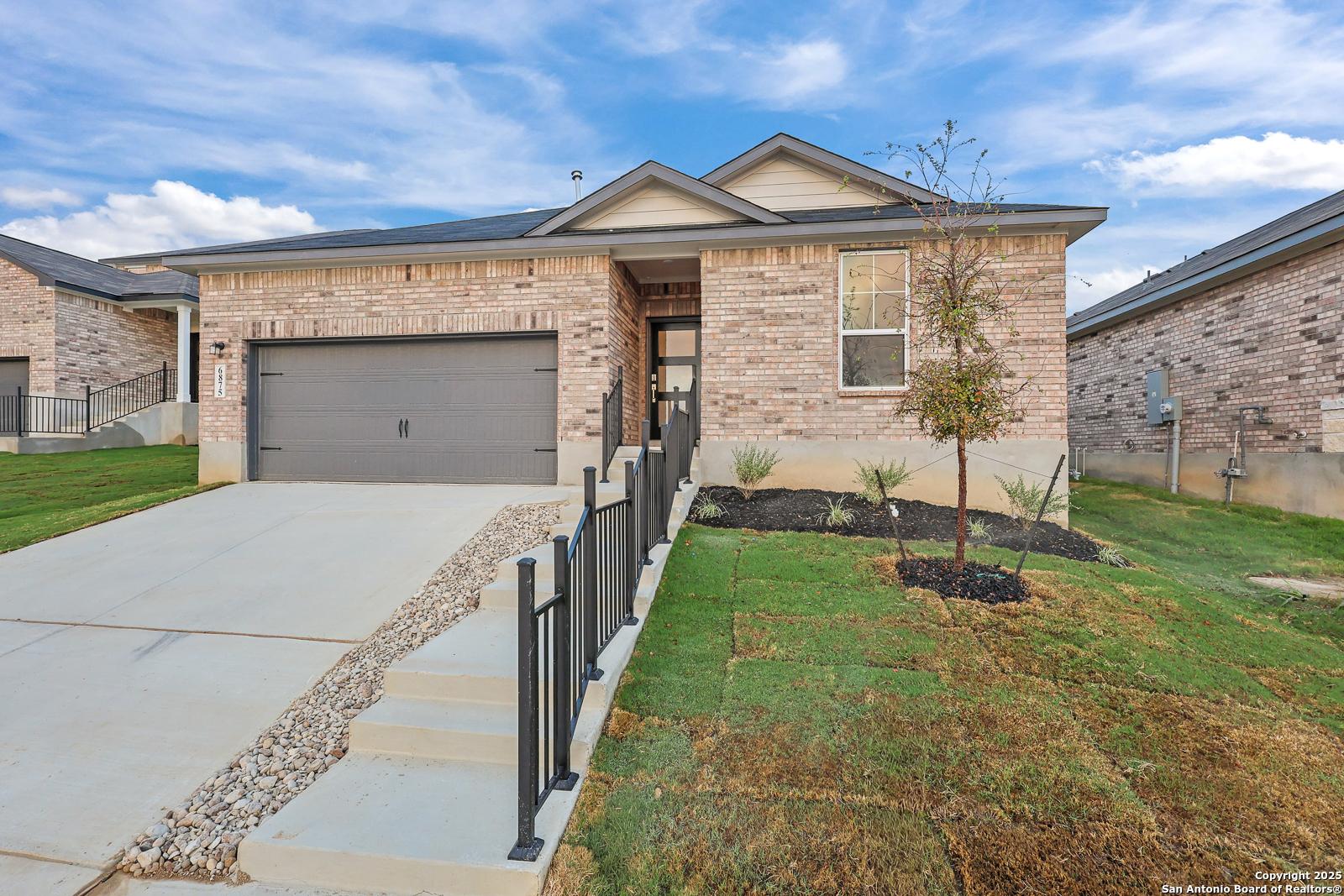 Modern brick single-story home with 2-car garage, front entrance, and landscaped yard in Comanche Ridge, San Antonio, Texas - Davidson Homes Asheville J