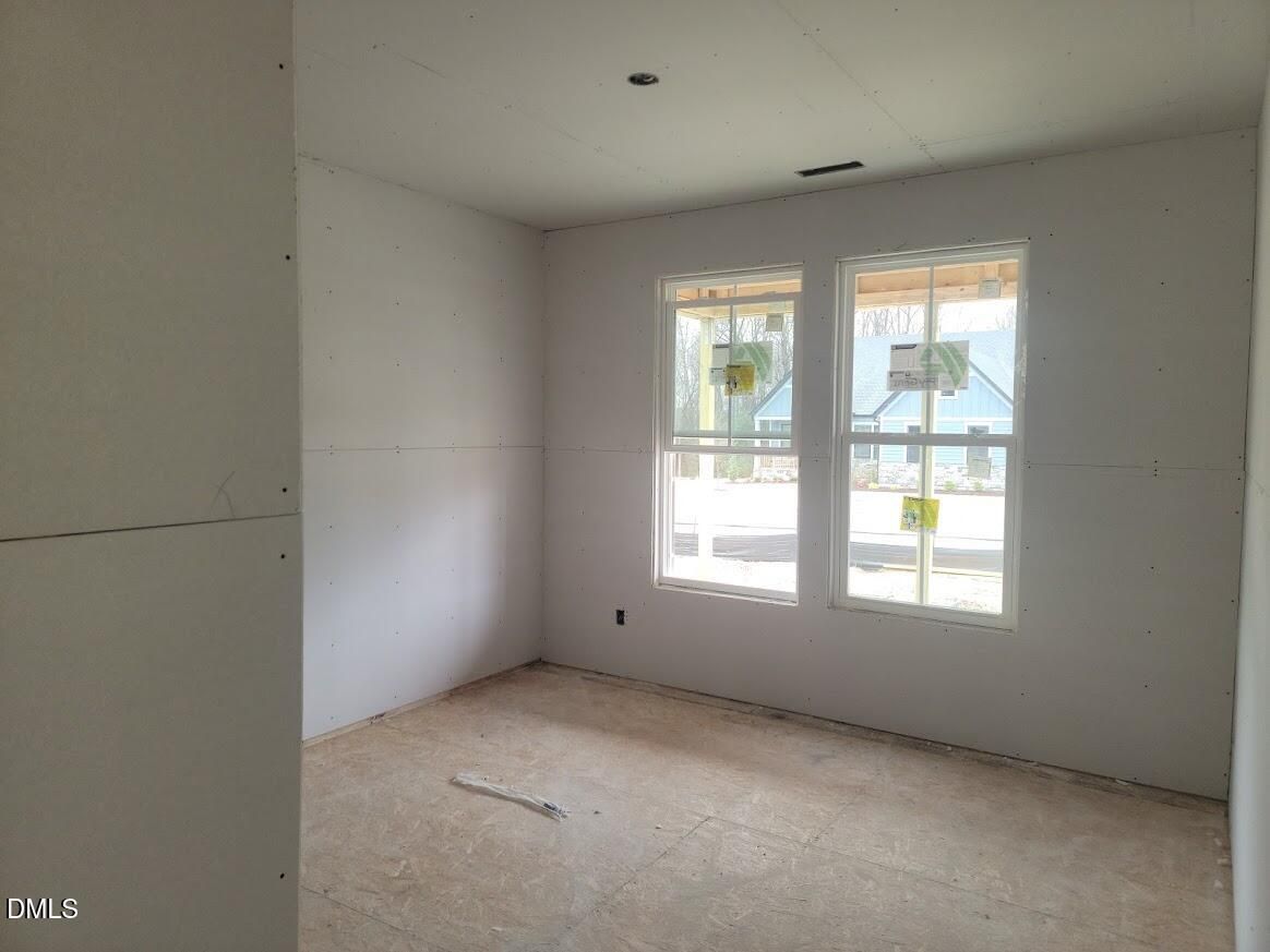 Unfinished bedroom with large double windows and fresh drywall in The Ashport G 5-bedroom home, Angier, North Carolina