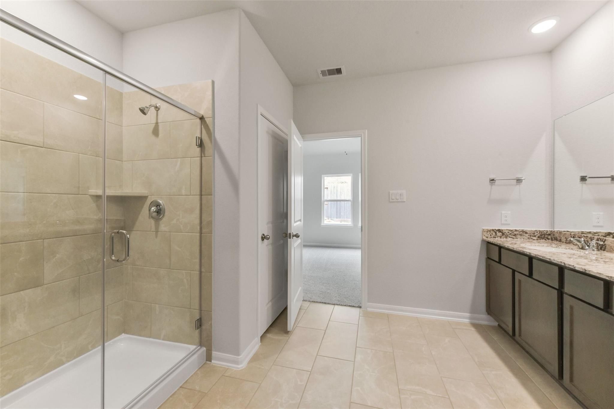 Modern master bath with frameless glass shower, subway tile, double vanity in Davidson Homes The Laguna B, Magnolia TX