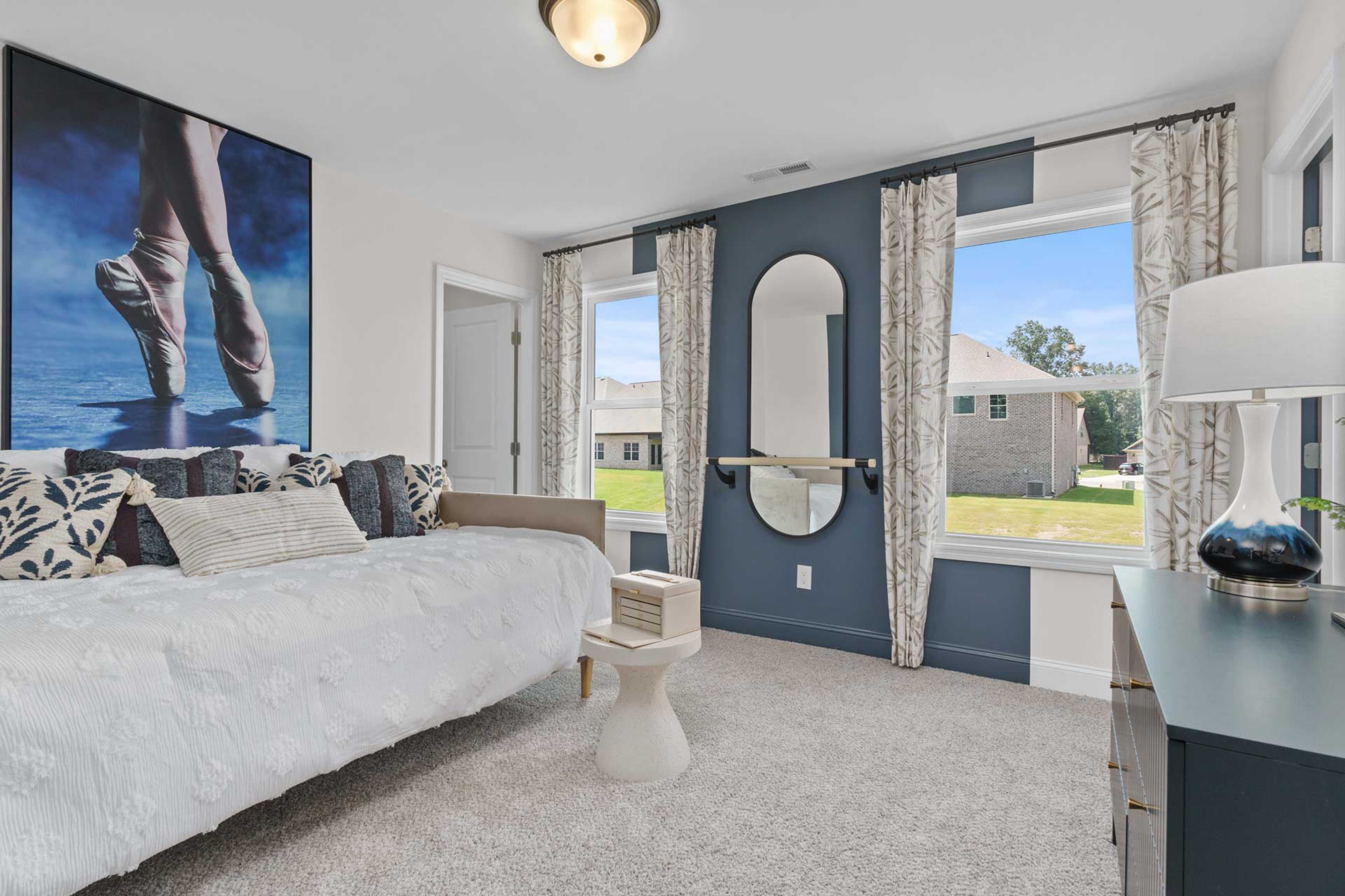 Cozy bedroom at Creek Grove in New Market Alabama with white bed, ballet slipper wall art, arched mirror, and window view of green yard