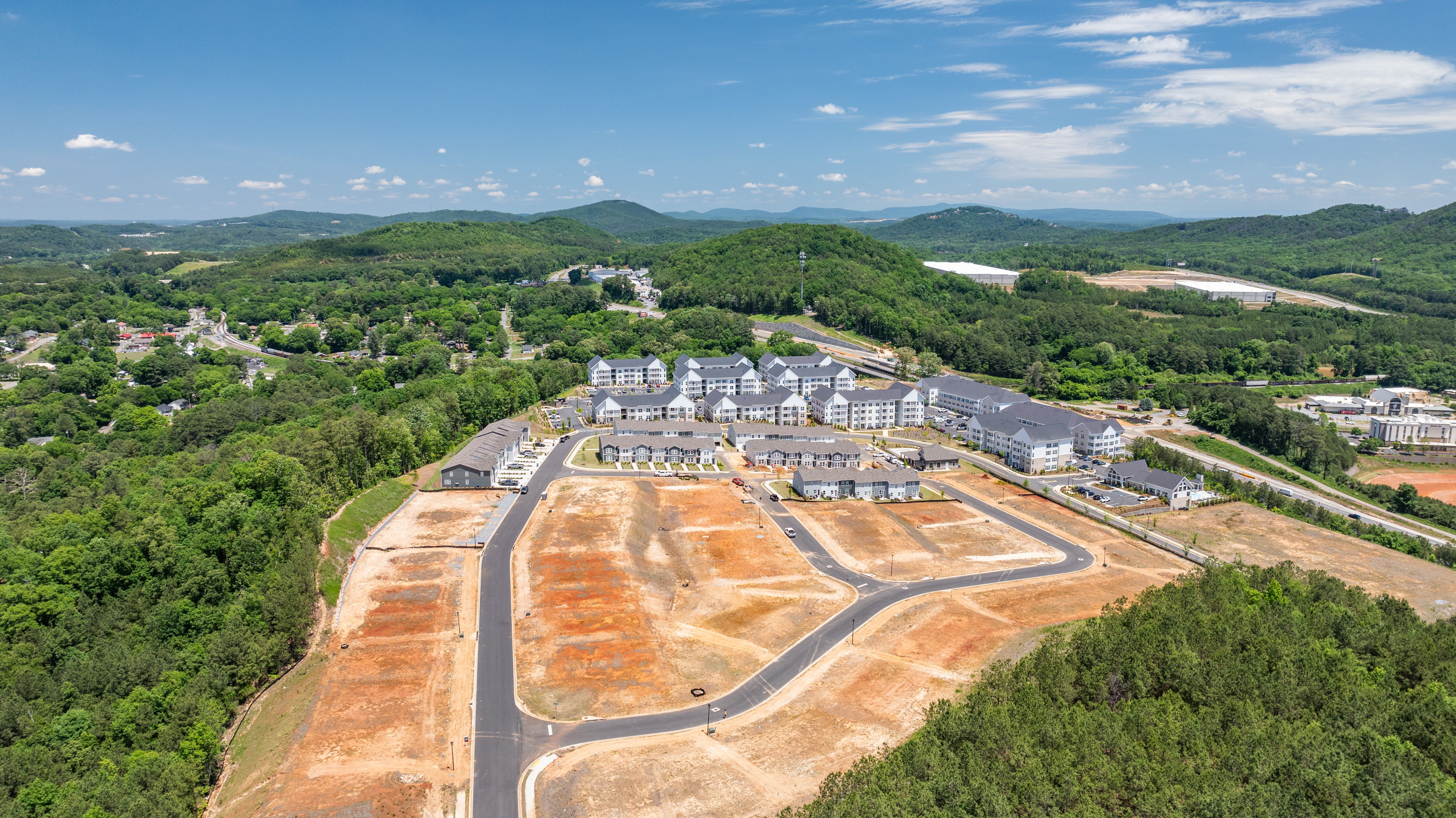 Aerial view of Stegall Village in Emerson Georgia showcasing white townhomes, green lawns, autumn woodlands, and distant mountains