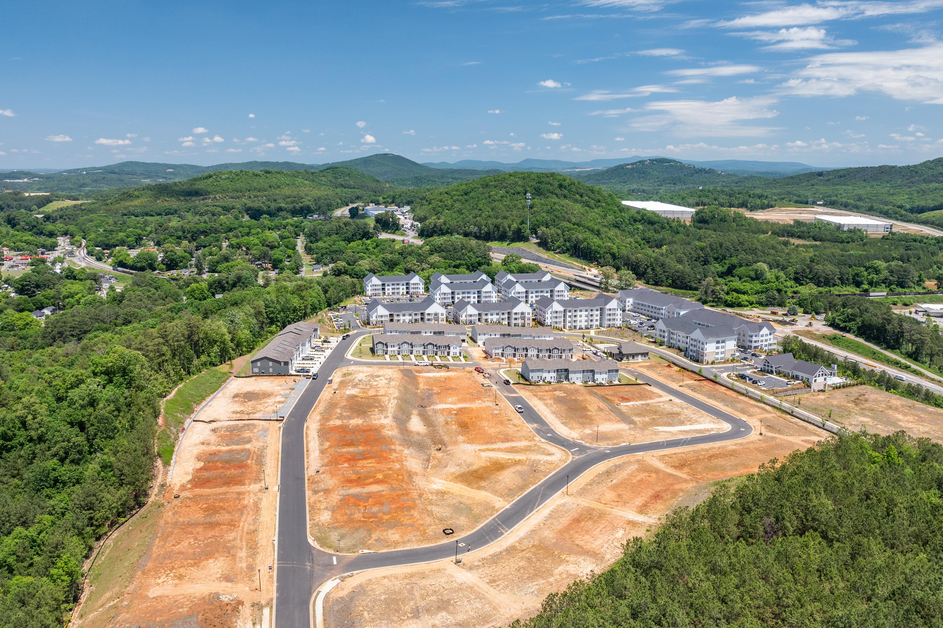 Aerial view of Stegall Village in Emerson Georgia showcasing white townhomes, green lawns, autumn woodlands, and distant mountains