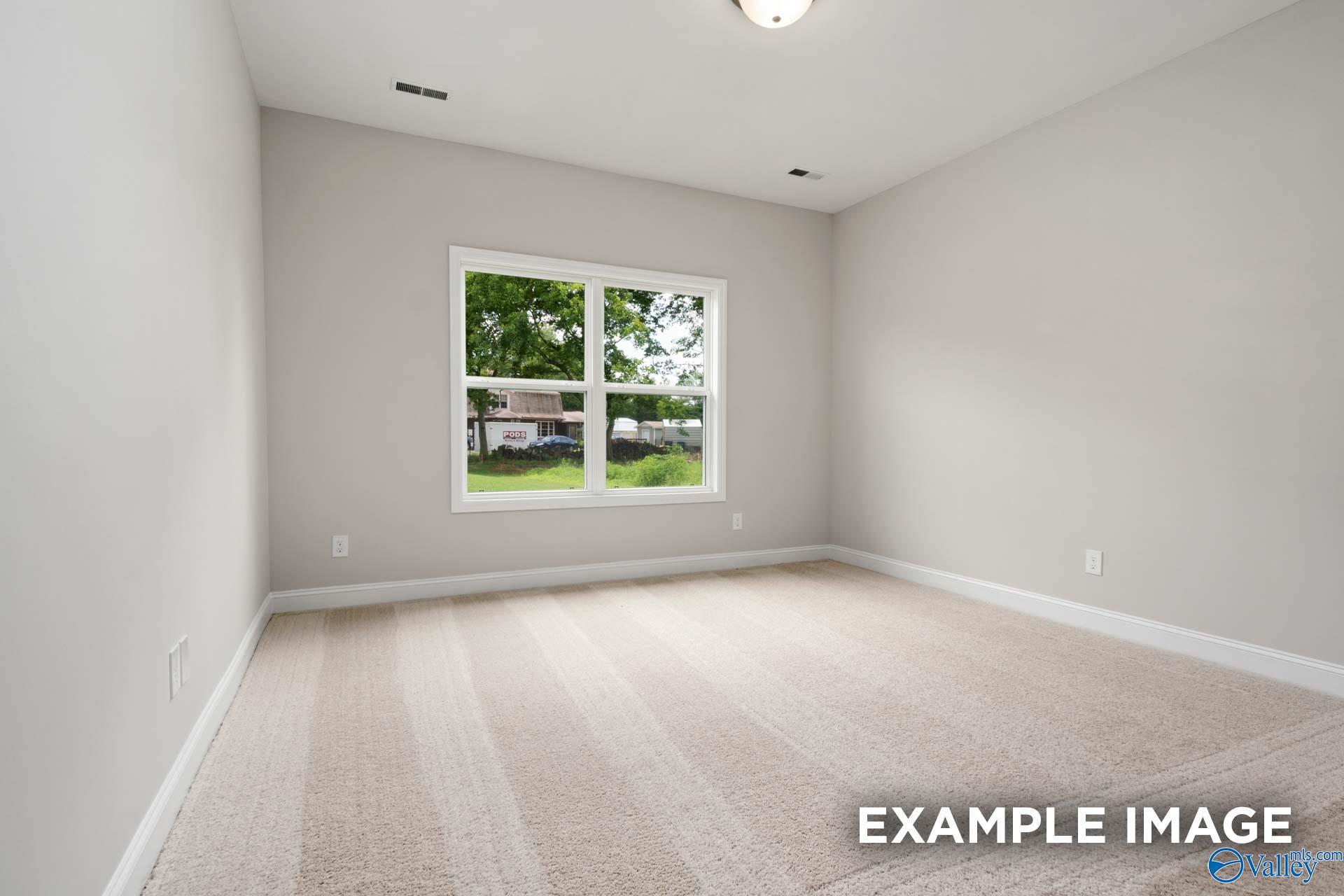 Bright empty bedroom with large window and tree view in Davidson Homes The Asheville C, Meridianville, Alabama