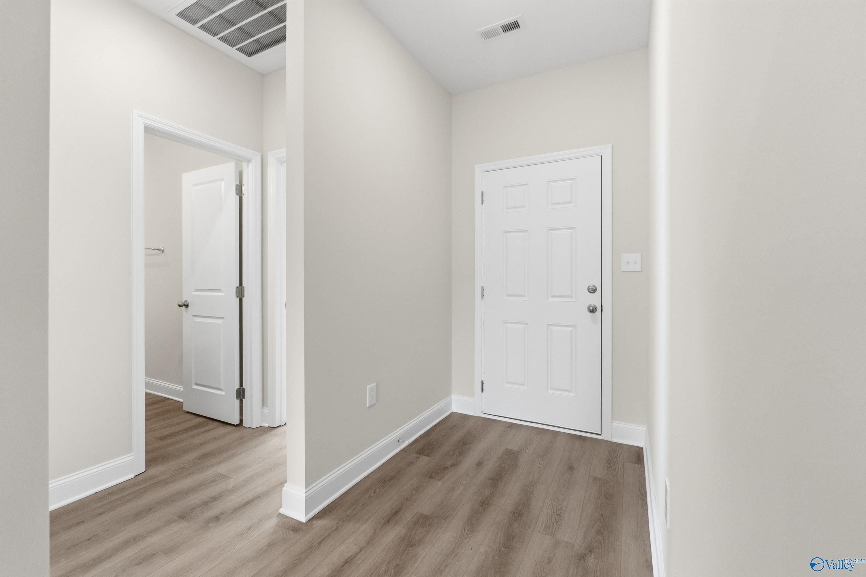 Bright hallway with light wood flooring and white interior doors in 3-bedroom The Asheville C home, Huntsville, Alabama