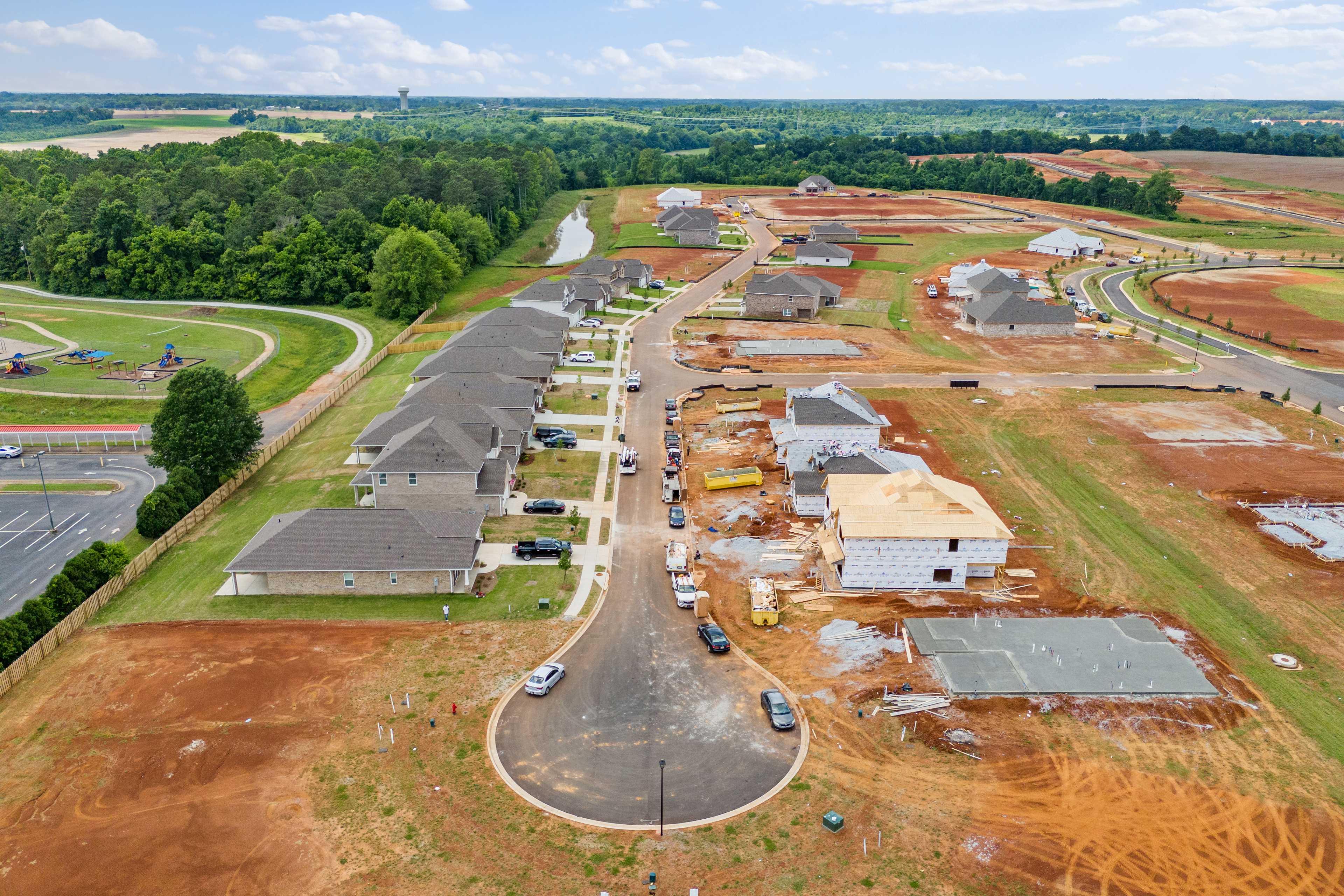 Aerial view of Creekside neighborhood under construction in Harvest Alabama with new townhomes playground and basketball court