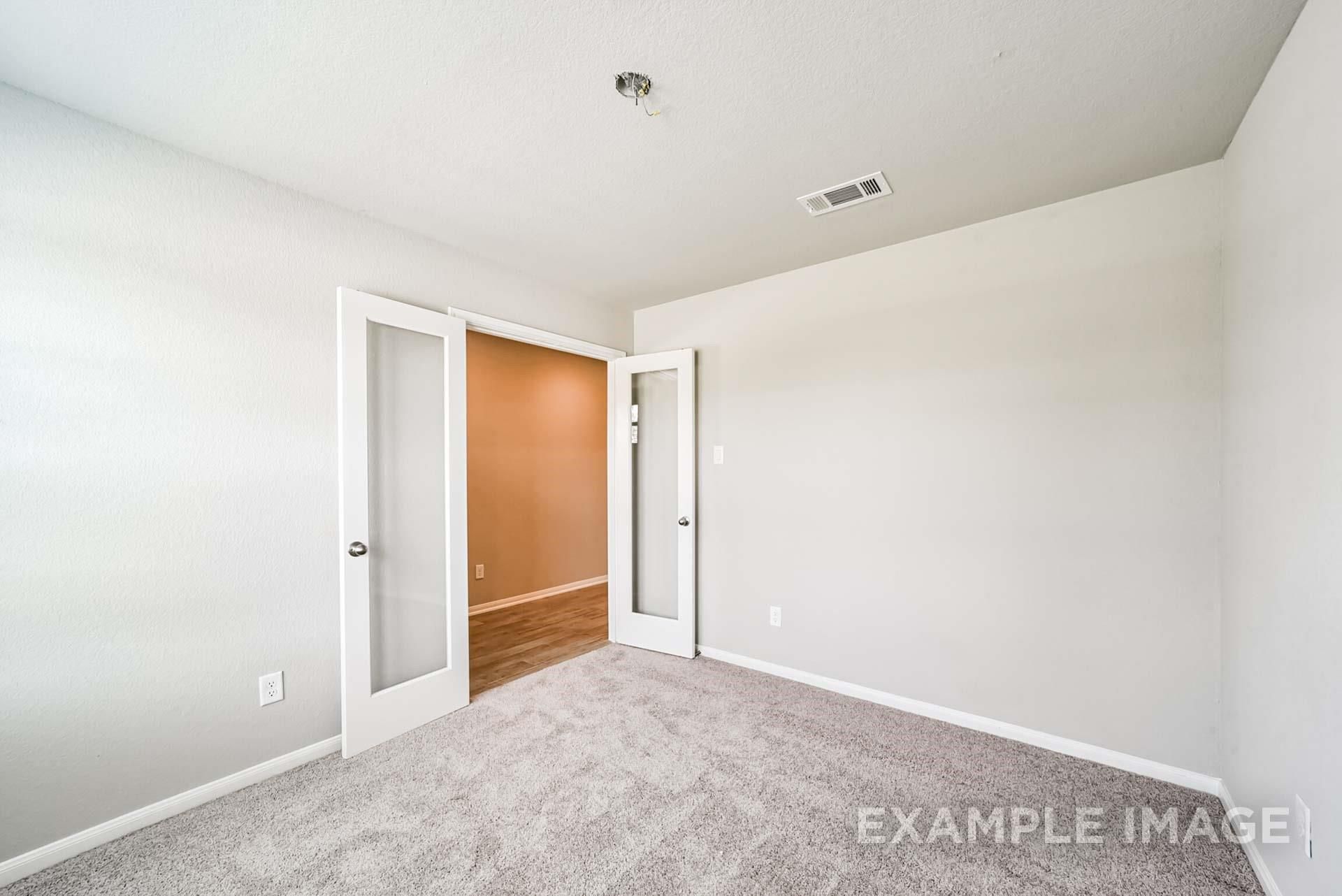 Bright home office or bedroom with French doors in The Riviera A floor plan by Davidson Homes in Emberly, Beasley, Texas.