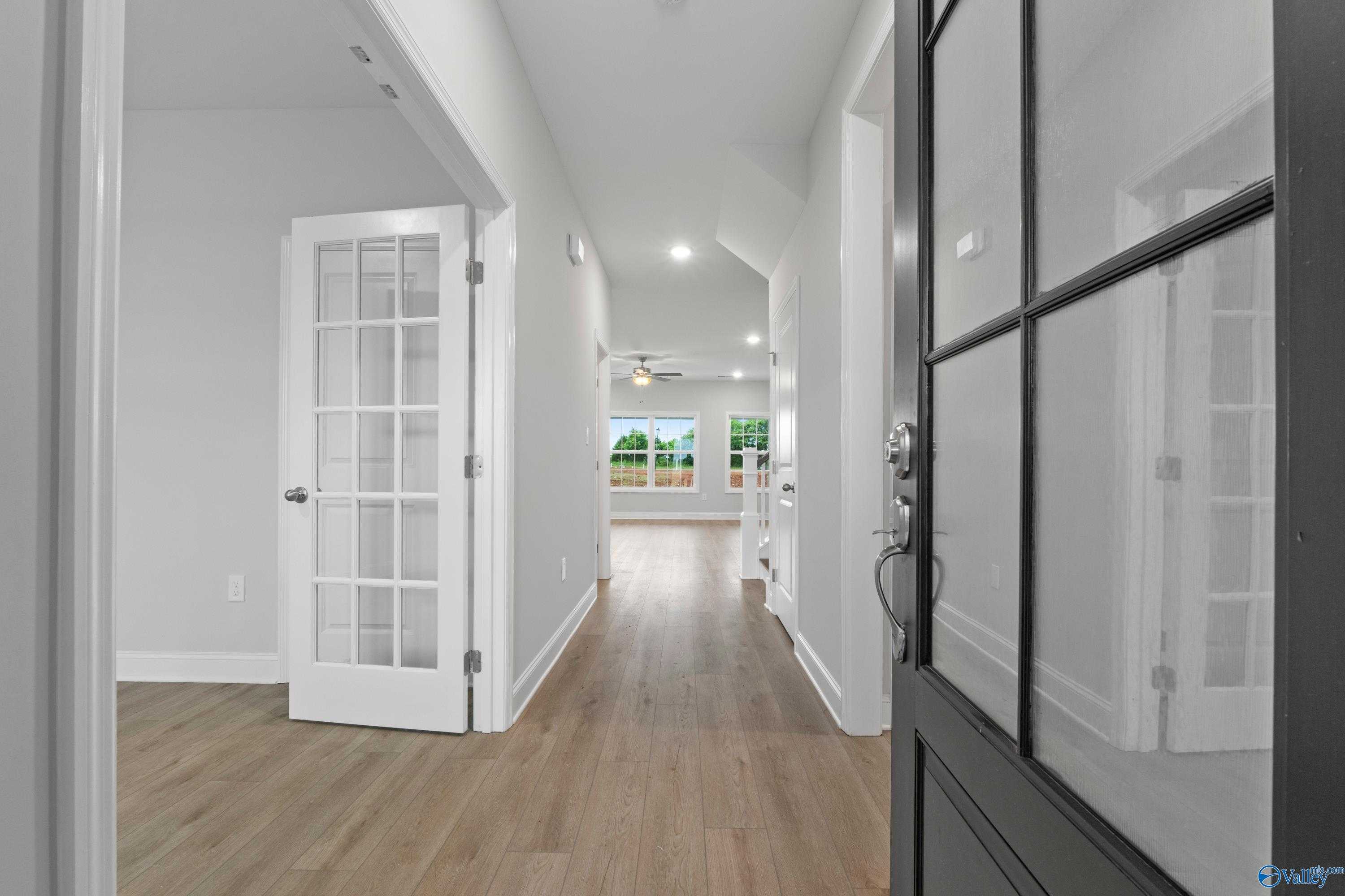 Bright hallway with hardwood floors, French doors, and glass front entry in Davidson Homes The Rockford B, Toney, AL