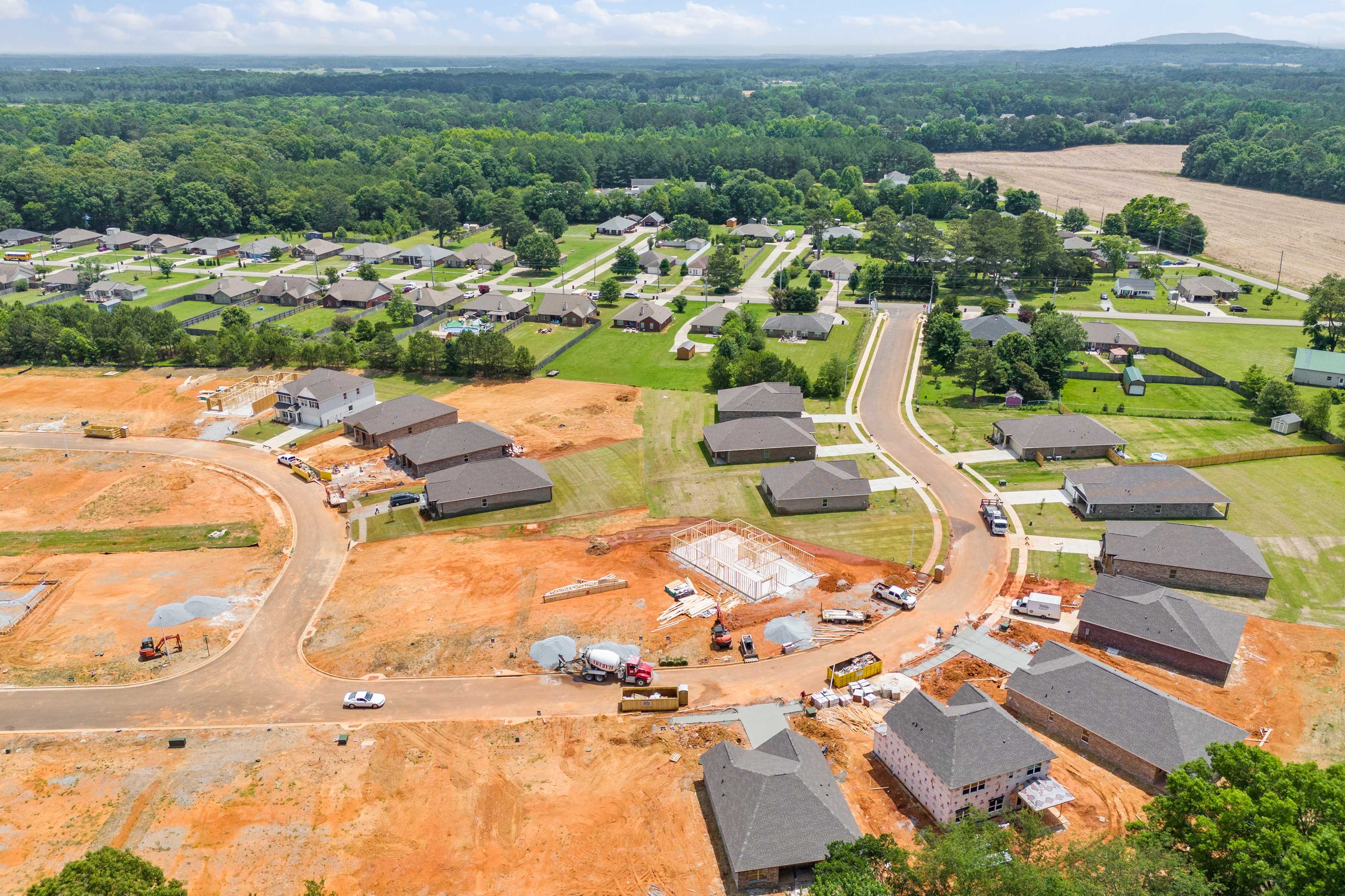 Aerial view of Durham Farms in Harvest Alabama showcasing new homes under construction by Davidson Homes amid woods and fields