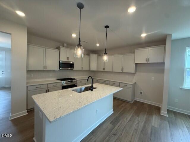 Modern kitchen with granite island and pendant lighting in The Birch II A floor plan at Montrose in Aberdeen, NC.