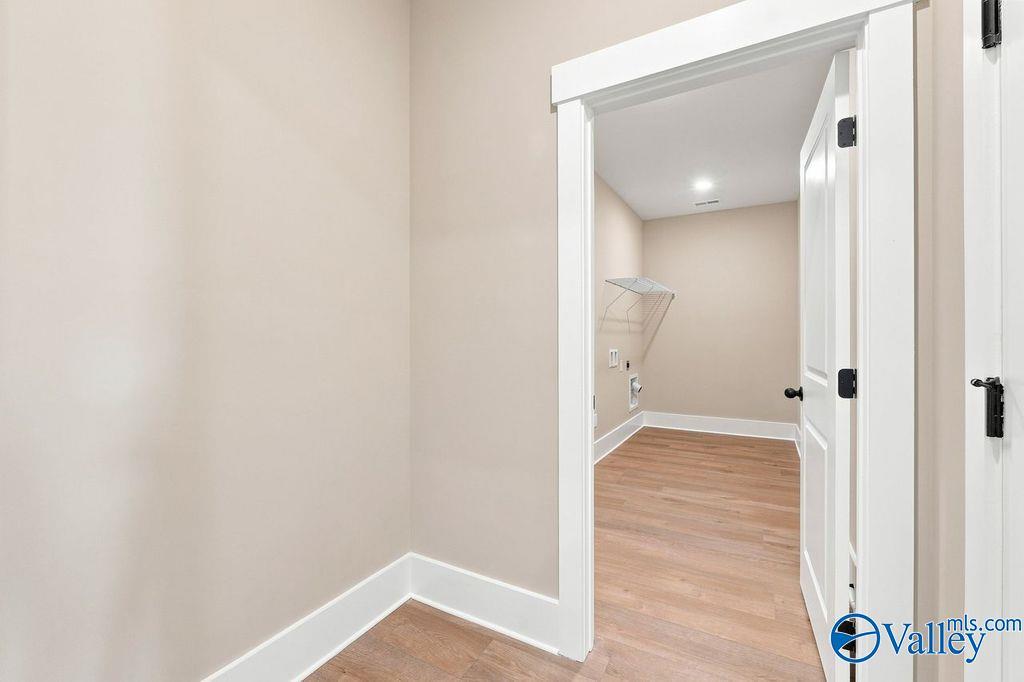 Spacious walk-in laundry room with wood-style flooring in The Rockford floor plan at Cain Park, Hartselle, Alabama.
