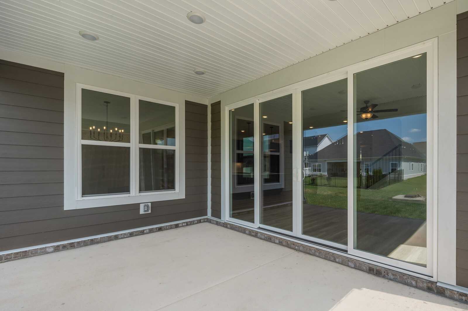 Covered back patio with sliding glass doors, ceiling fan, and lush yard view in Davidson Homes The Hathaway, Shelton Square, Murfreesboro, TN