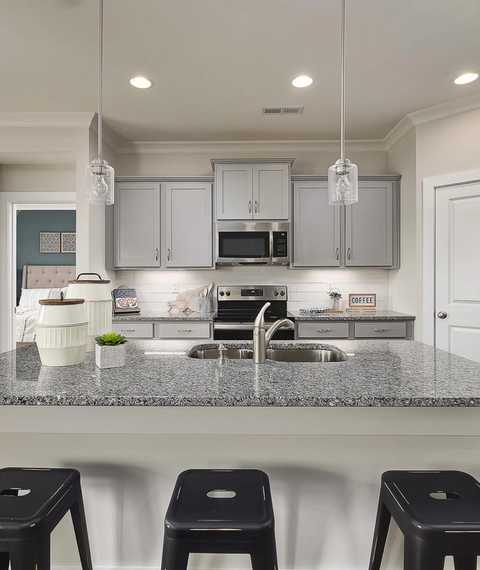 kitchen with gray cabinets and stainless steel appliances at The Reserve at North Ridge in Cullman, AL