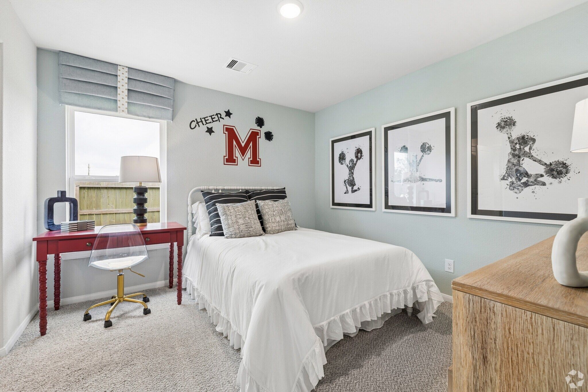Cozy girl's bedroom at Windmill Estates in Magnolia Texas with mint green walls, floral bedding, Mickey Mouse art, and red desk