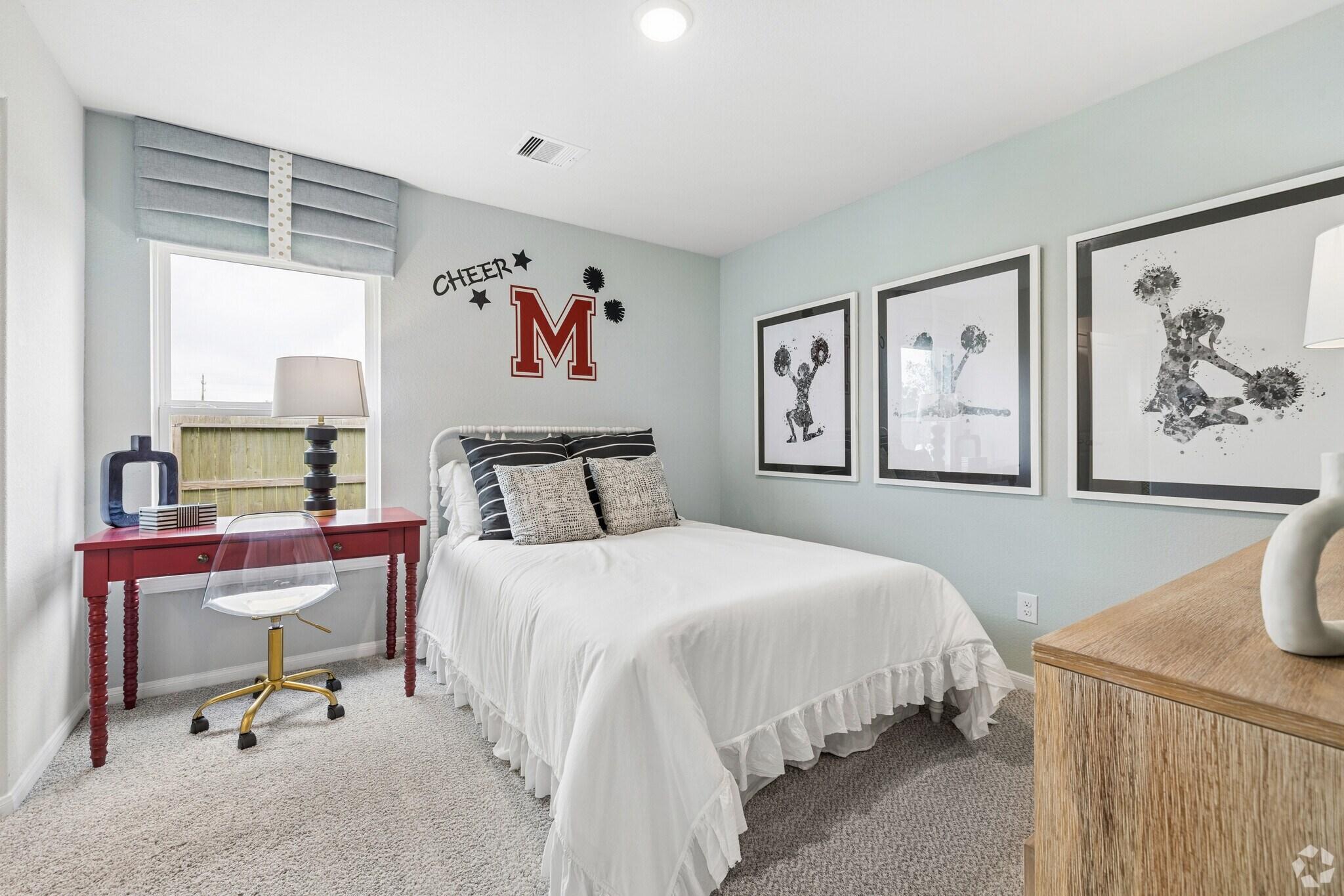 Cozy girl's bedroom at Windmill Estates in Magnolia Texas with mint green walls, floral bedding, Mickey Mouse art, and red desk