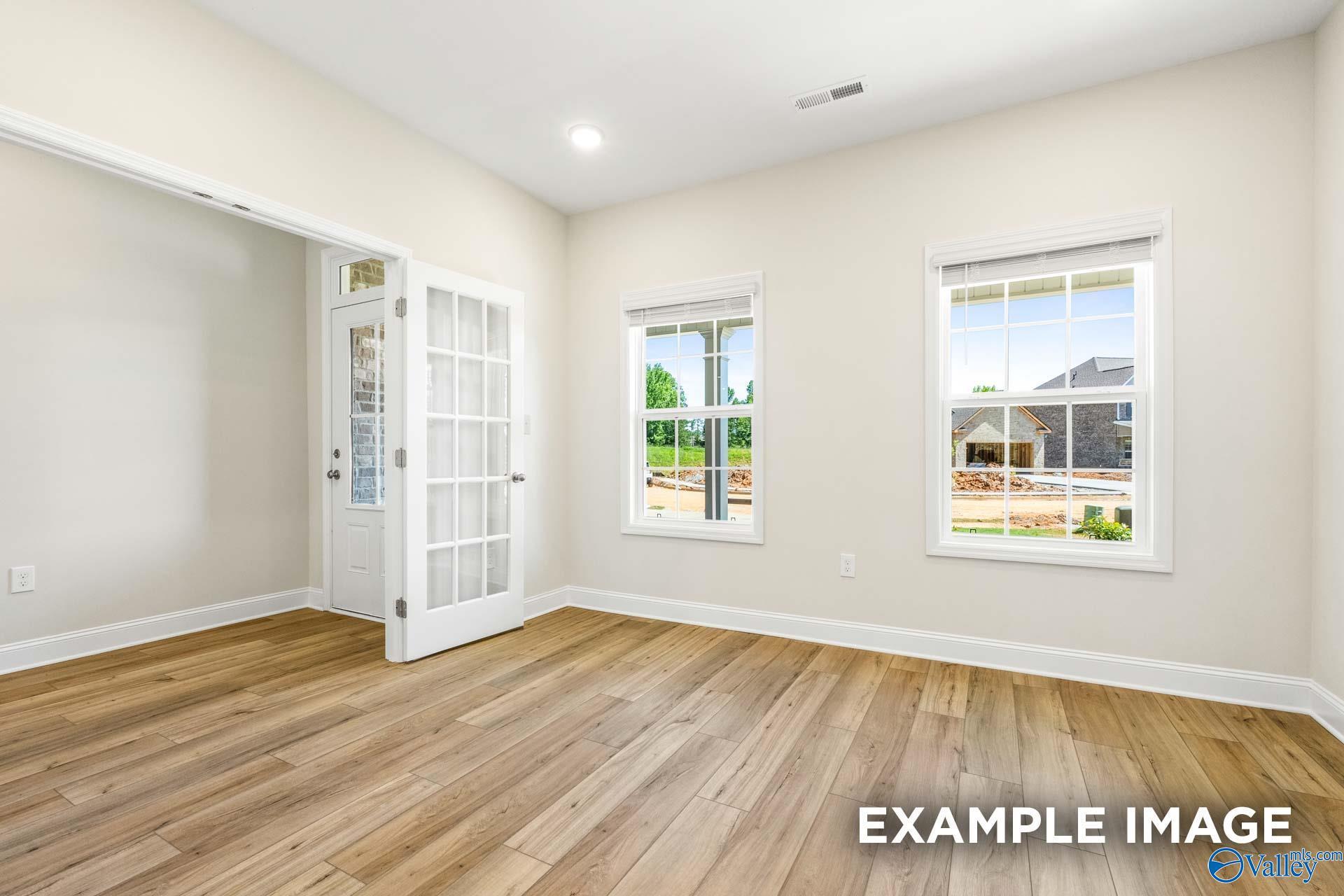 Bright flexible room with luxury vinyl plank flooring, French doors, and large windows in Davidson Homes The Shelby B, Ramsay Cove, Owens Cross Roads, Alabama