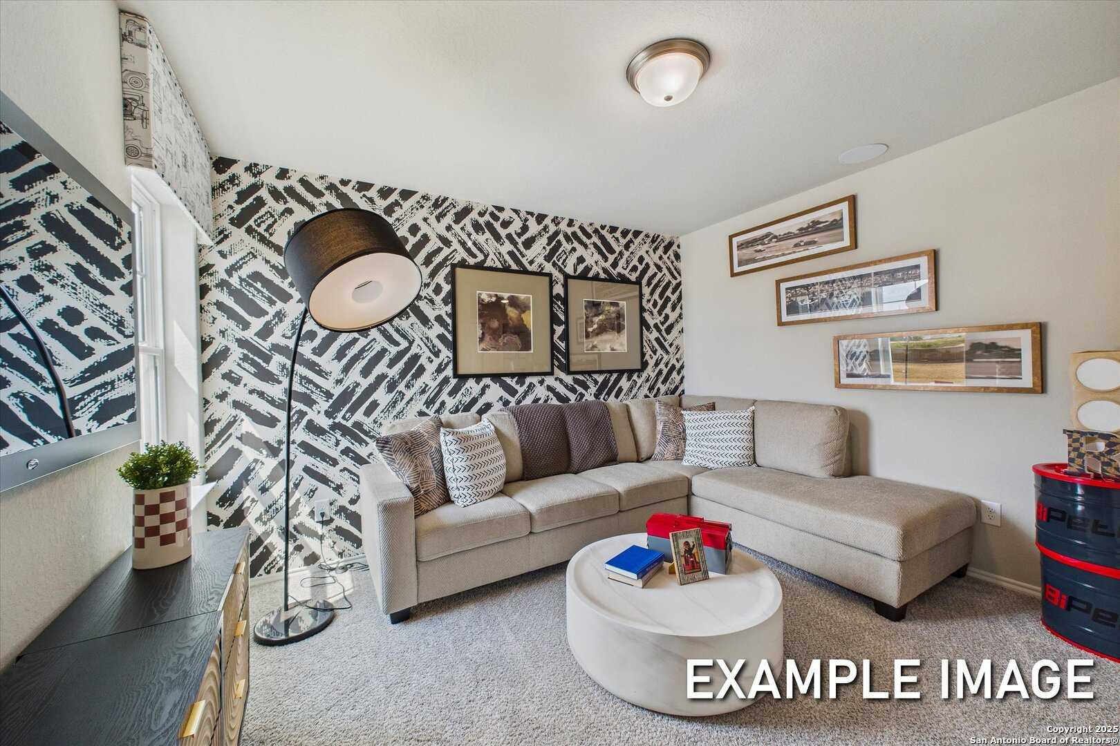Cozy living room with patterned accent wall, L-shaped beige sofa, arc lamp, and framed art in Davidson Homes The Sabine C, San Antonio