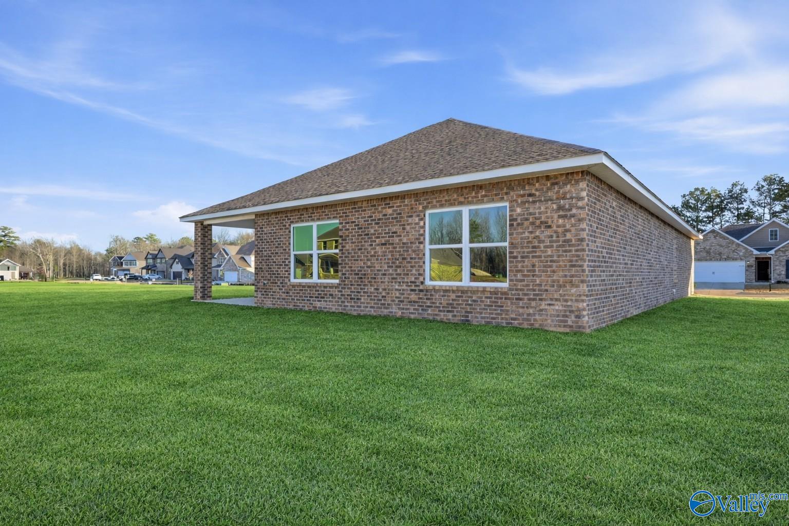 Brick single-story home with gabled shingle roof, white-trimmed windows, and 2-car garage amid green lawn, Davidson Homes The Daphne C, Athens AL