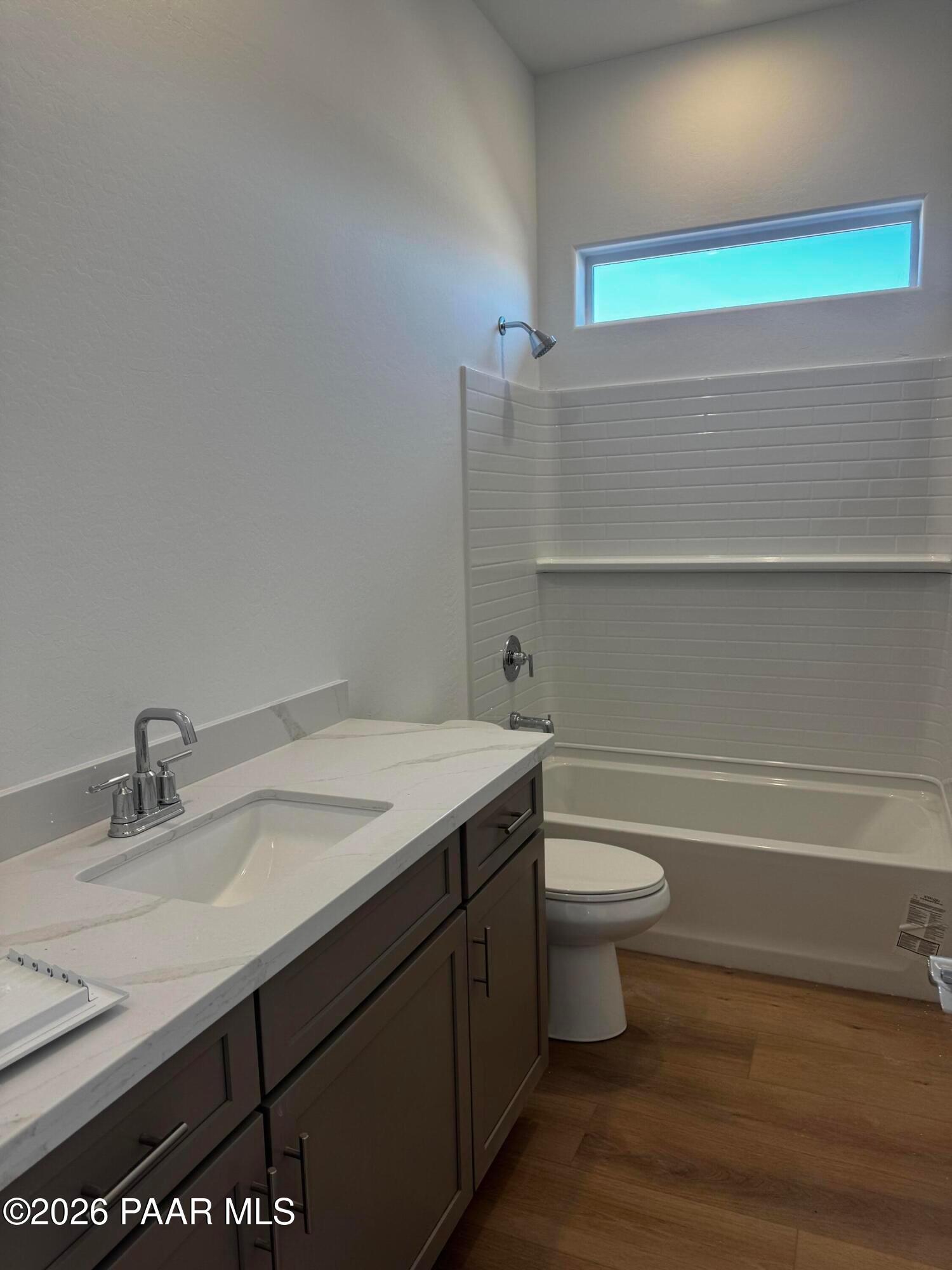 Modern bathroom with white subway tile shower, soaking tub, quartz vanity, dark cabinets, and clerestory window in Davidson Homes The Blaze C, Prescott, AZ