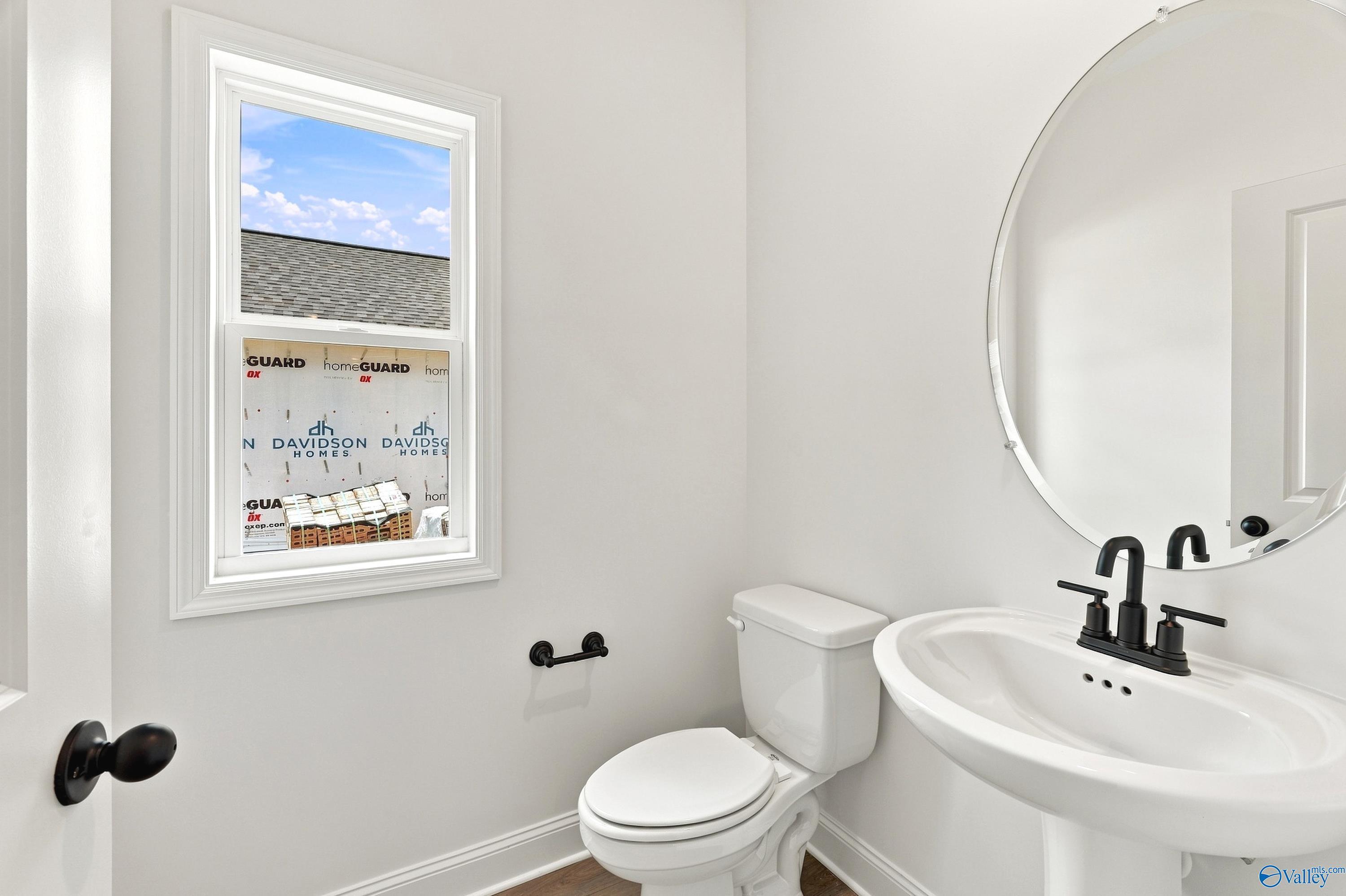 Modern half-bath with pedestal sink and matte black fixtures in The Shelby B floor plan at Jaguar Hills, Huntsville, AL.