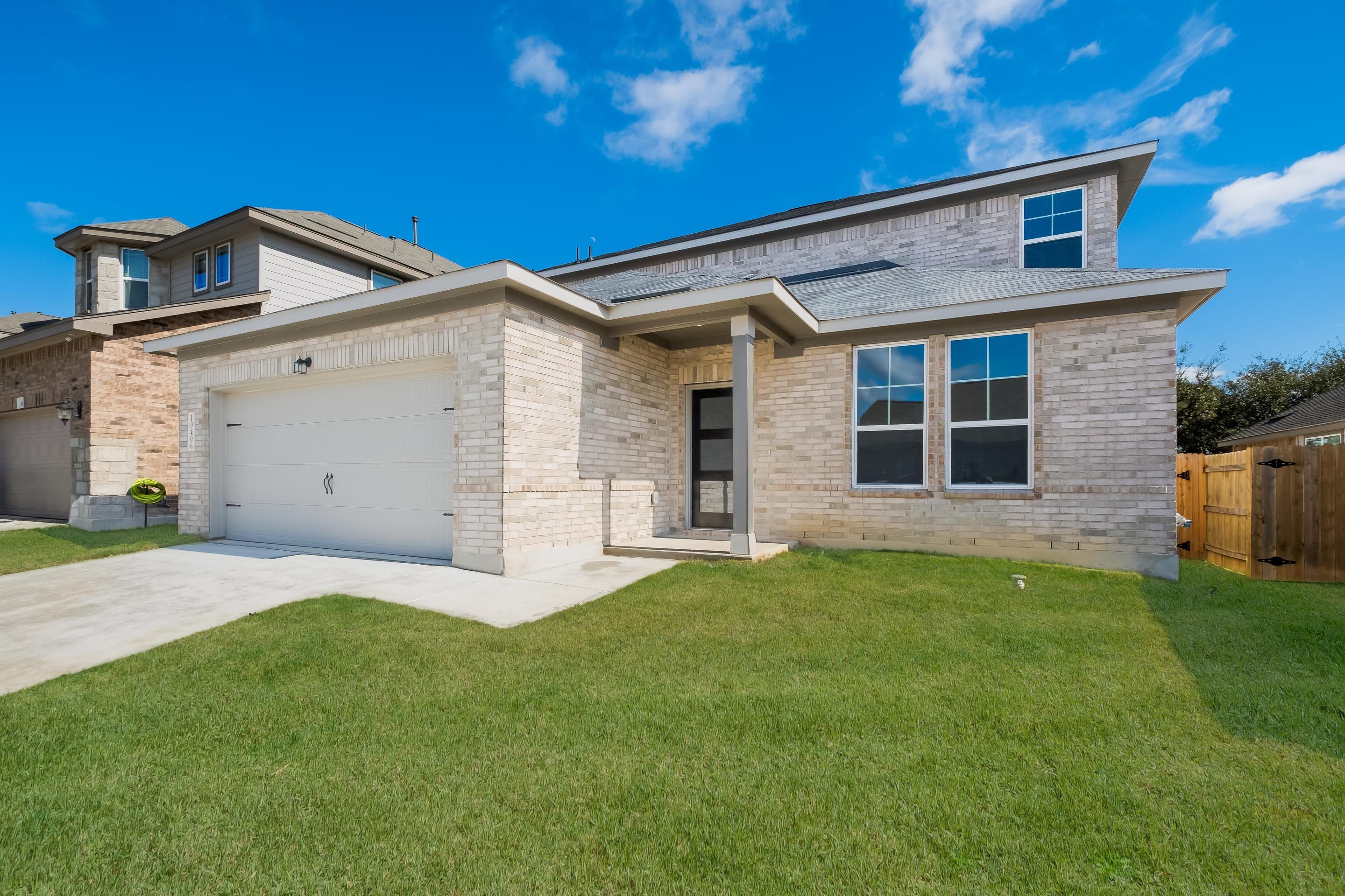 Contemporary brick ranch home exterior at Bricewood in San Antonio TX with attached garage and covered porch