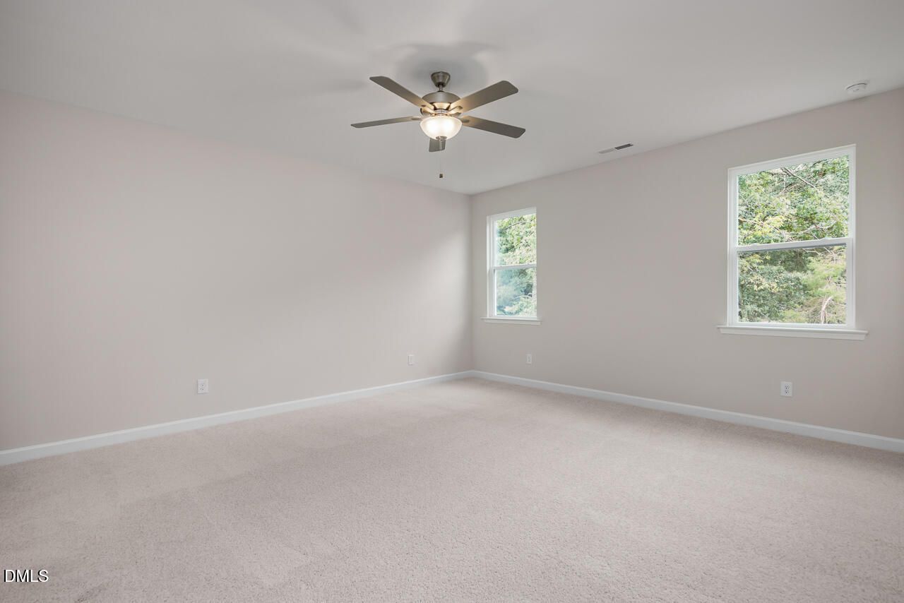 Spacious, neutral-toned bedroom with ceiling fan in The Hickory II C floor plan at Montrose, Aberdeen, North Carolina.