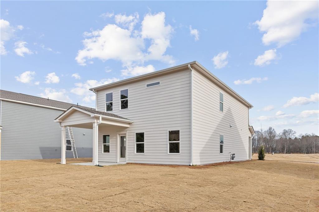 Two-story Rabun C home exterior with covered porch, two-car garage, and grassy yard in Cedar Farms, Winder, Georgia