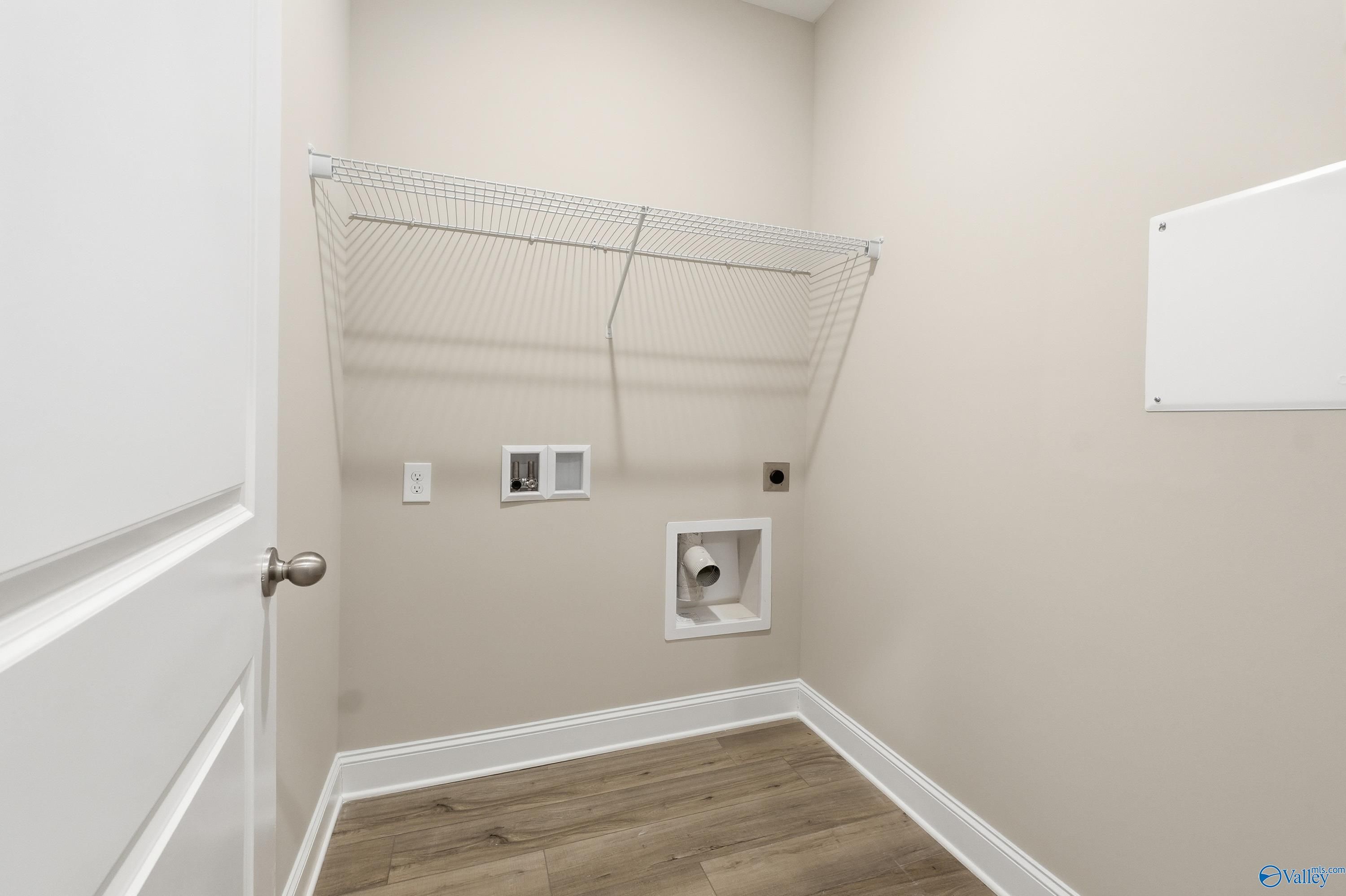Functional laundry room with wire shelving, washer/dryer hookups and utility drain in Davidson Homes The Asheville, Arab, Alabama