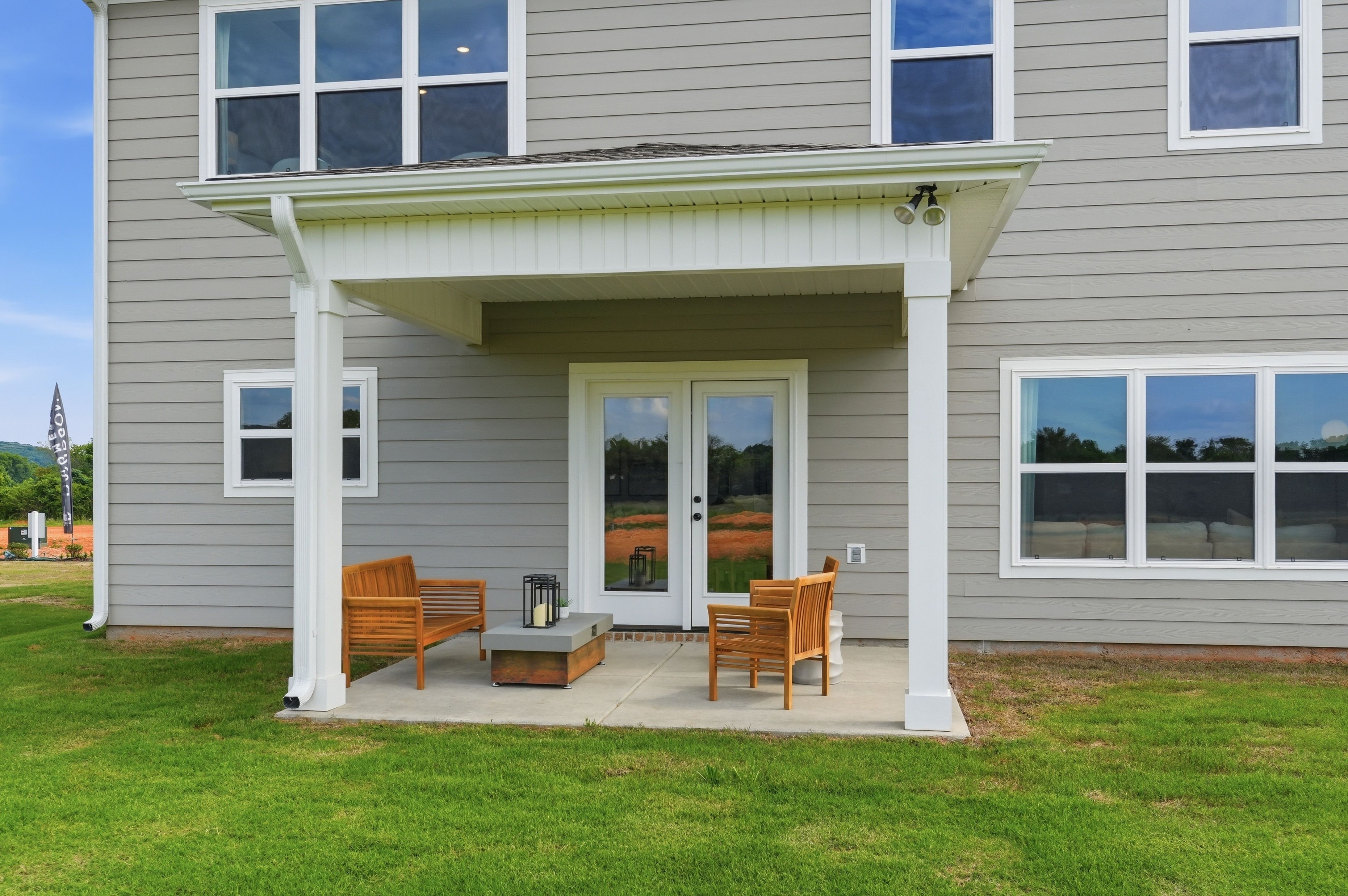 Covered back patio with wooden furniture at Berry Cove in New Market, Alabama, built by Davidson Homes.