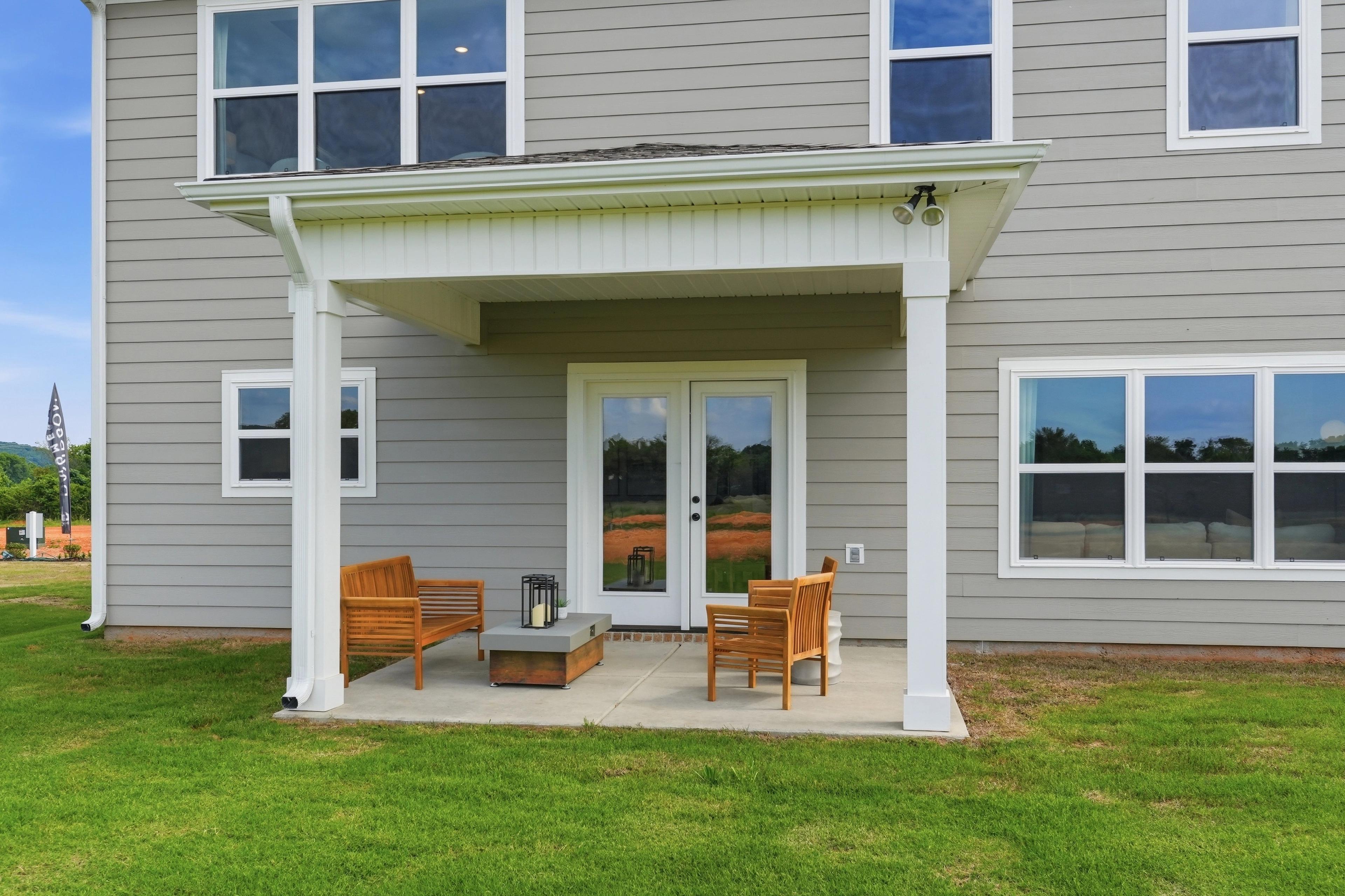 Covered back patio with wooden furniture at Berry Cove in New Market, Alabama, built by Davidson Homes.