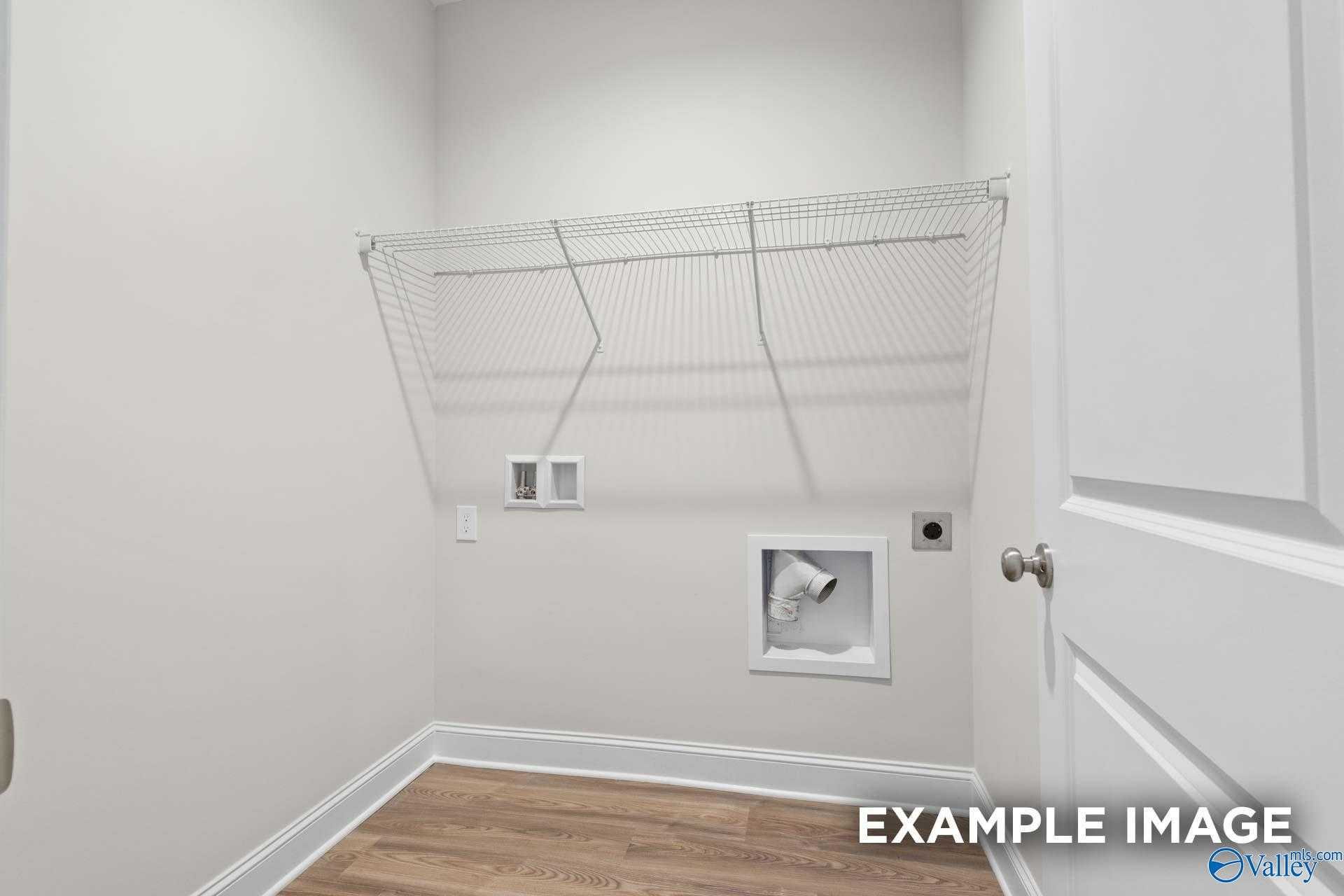 Spacious laundry room with wire shelving, washer-dryer hookups and wood flooring in Davidson Homes The Franklin C, Meridianville, AL