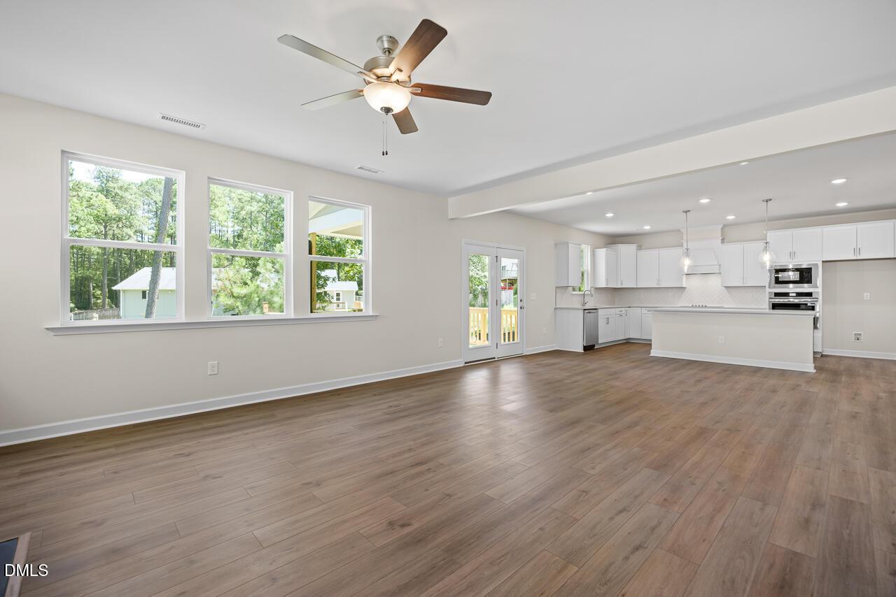 Open-concept living room and kitchen with white cabinetry in The Hickory II B floor plan, Montrose, Aberdeen, NC.