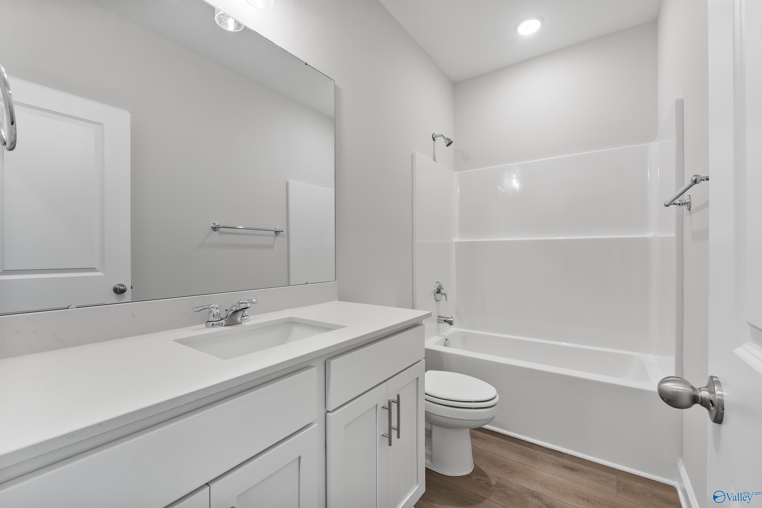 Modern guest bathroom featuring white vanity, tub-shower combo, and neutral tones in Davidson Homes The Daphne, Hazel Green, AL