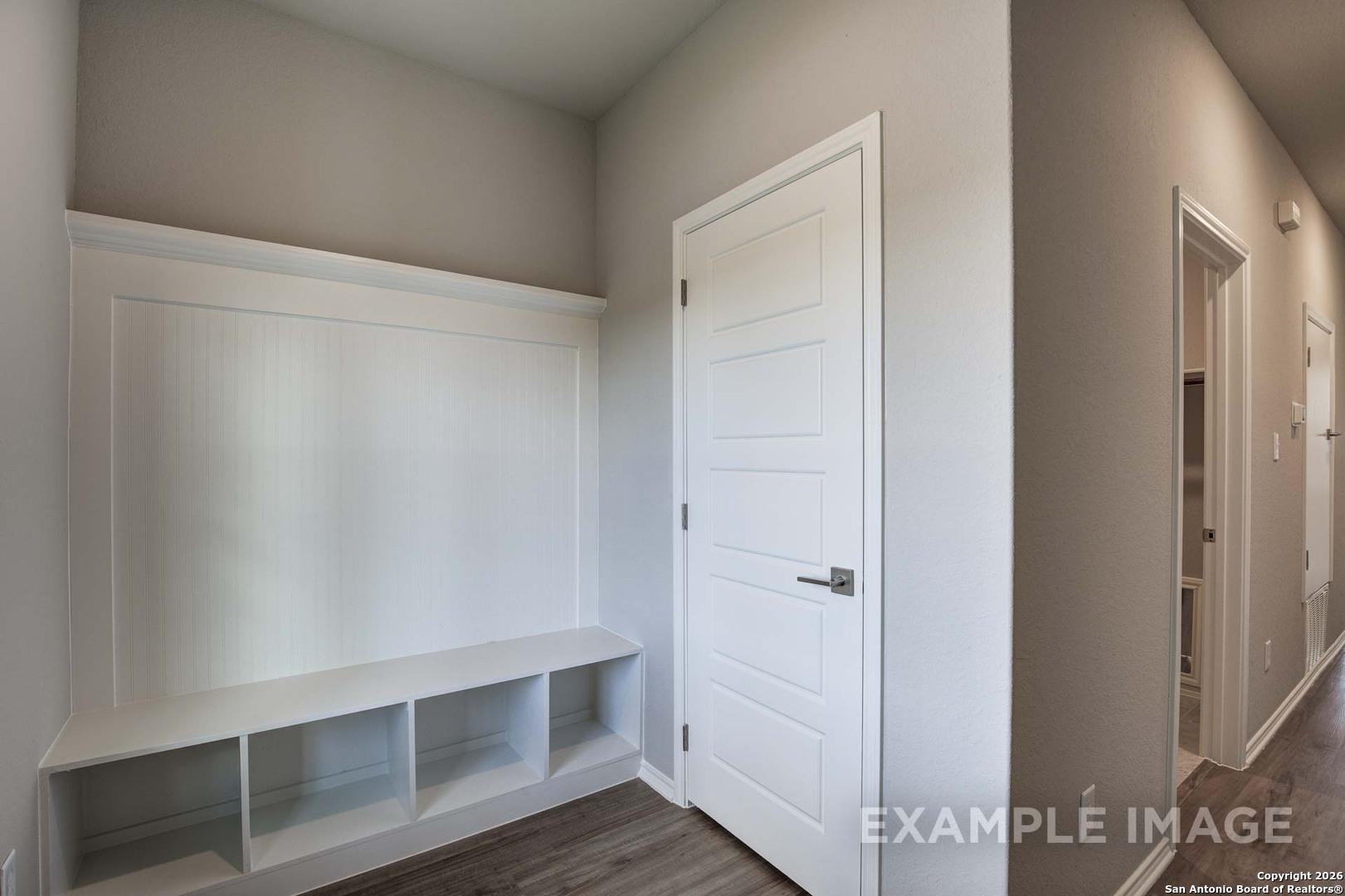 Built-in white mudroom benches with cubbies and open shelves in Davidson Homes The Frio C, Agave San Antonio Texas