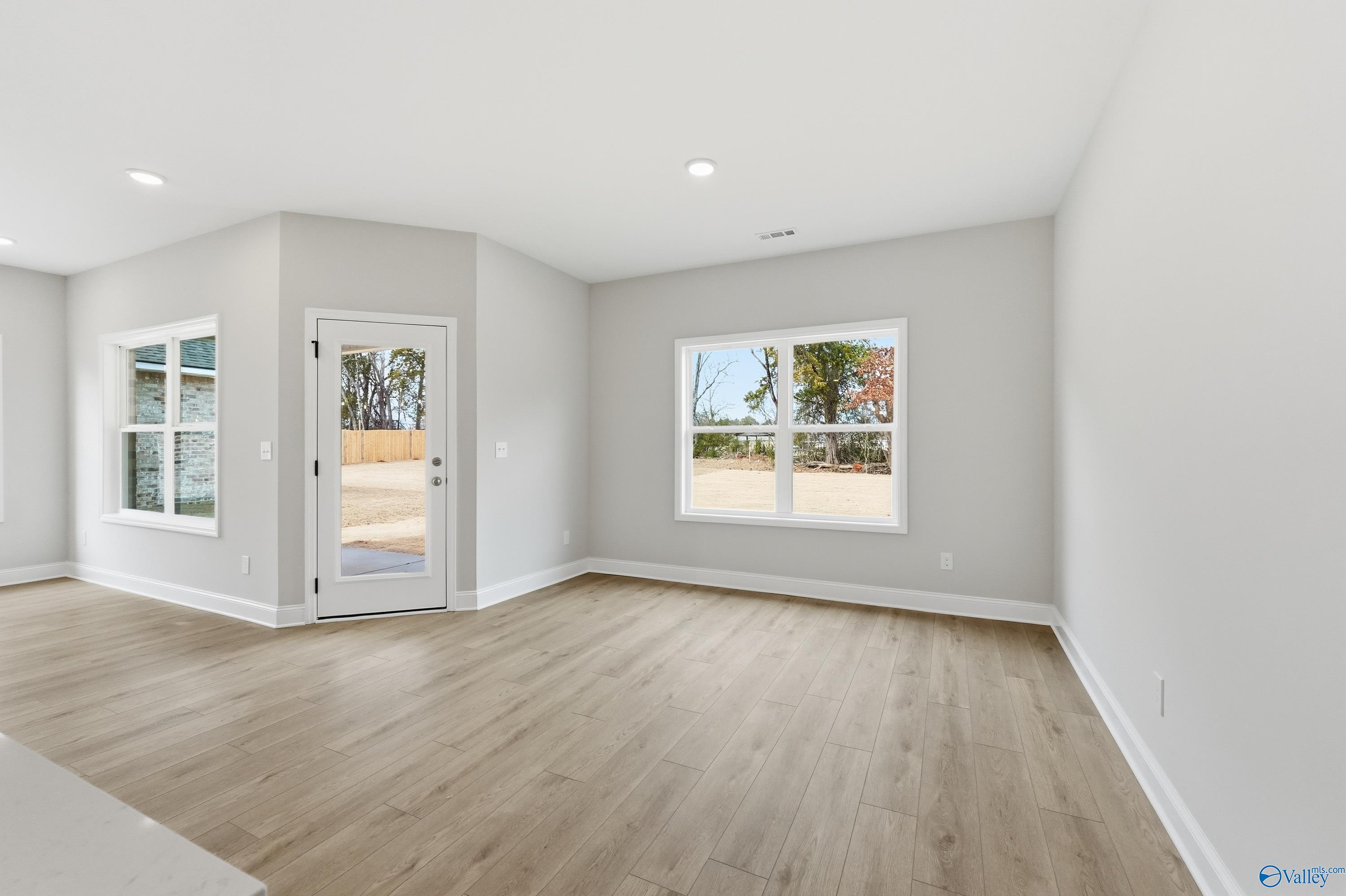 Bright flex room with gray walls, hardwood floors, French doors, and tree views in Davidson Homes The Franklin, Meridianville, Alabama