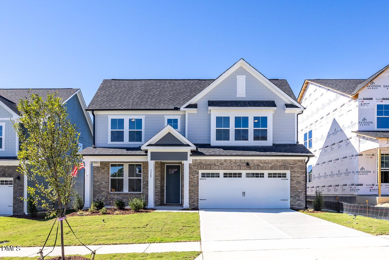 Two-story brick and siding exterior with 2-car garage and landscaped yard in Davidson Homes' The Ashport M, Wendell Ridge, NC