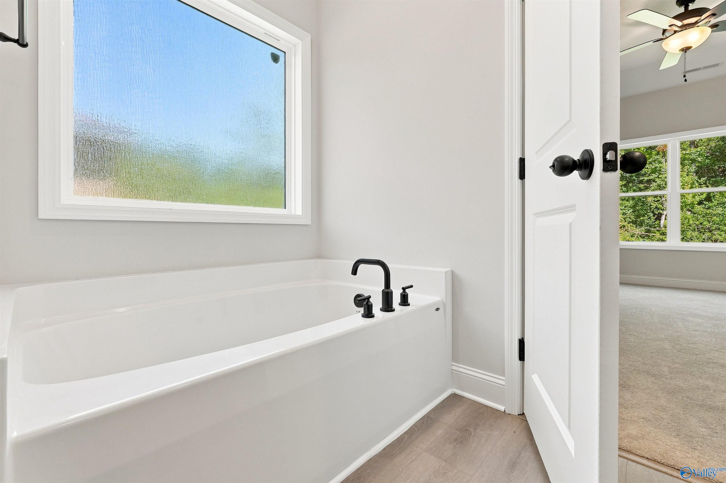 Modern soaking tub with matte black faucet in The Daphne floor plan by Davidson Homes in Spragins Cove, Huntsville, Alabama.