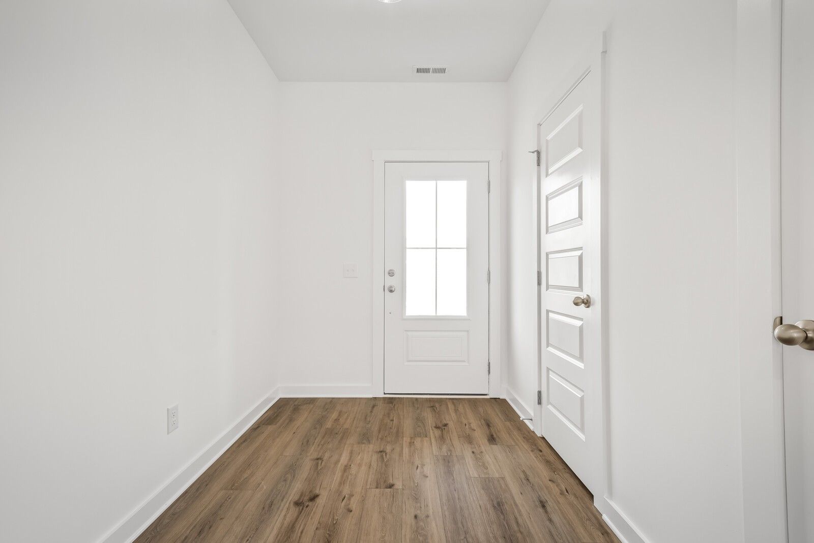 Bright entryway with white walls, hardwood floors, and glass-paneled door in Davidson Homes The Gordon C, White House, TN