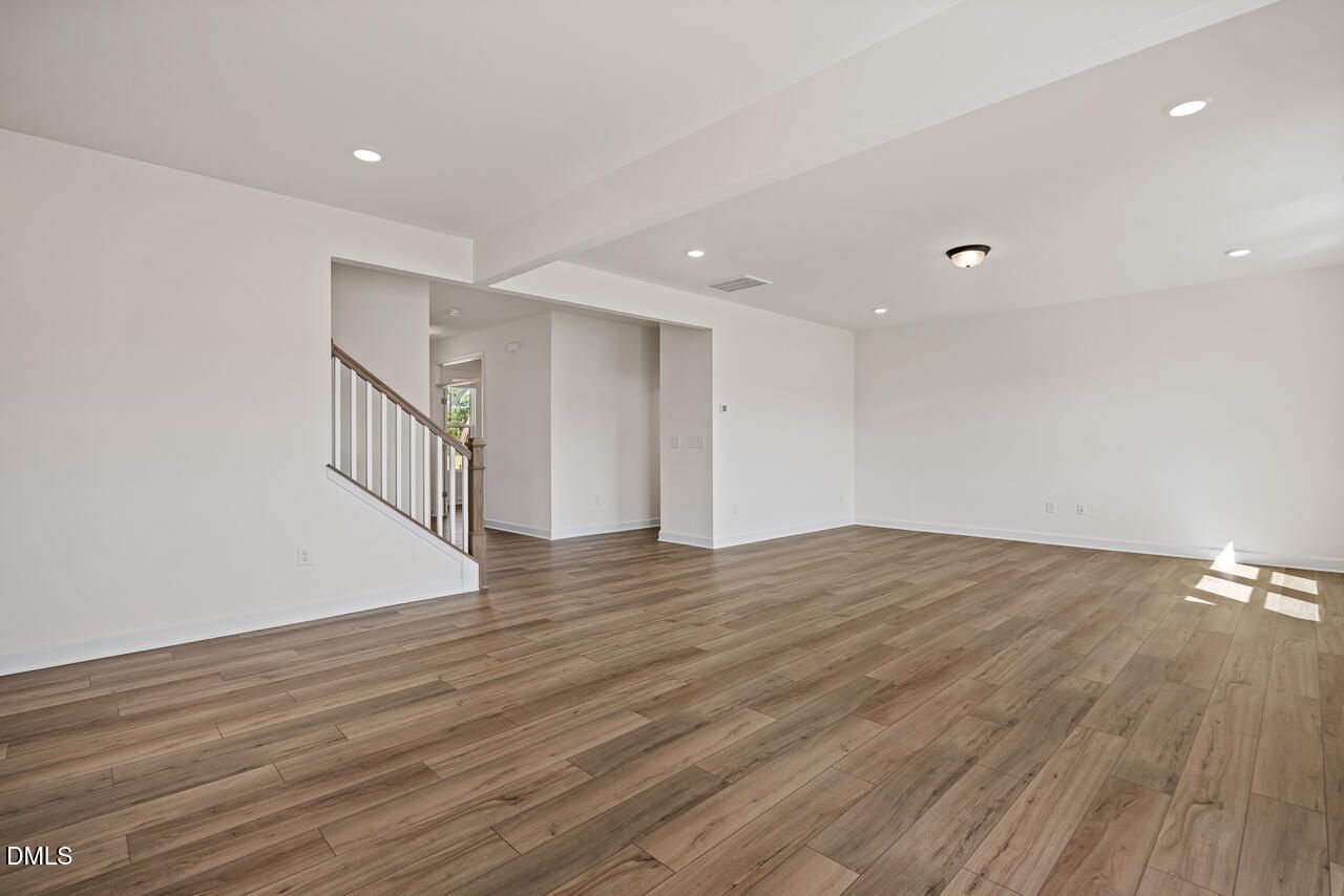 Spacious open-concept living area with luxury vinyl plank flooring and staircase in Davidson Homes Hickory II B, Lillington NC