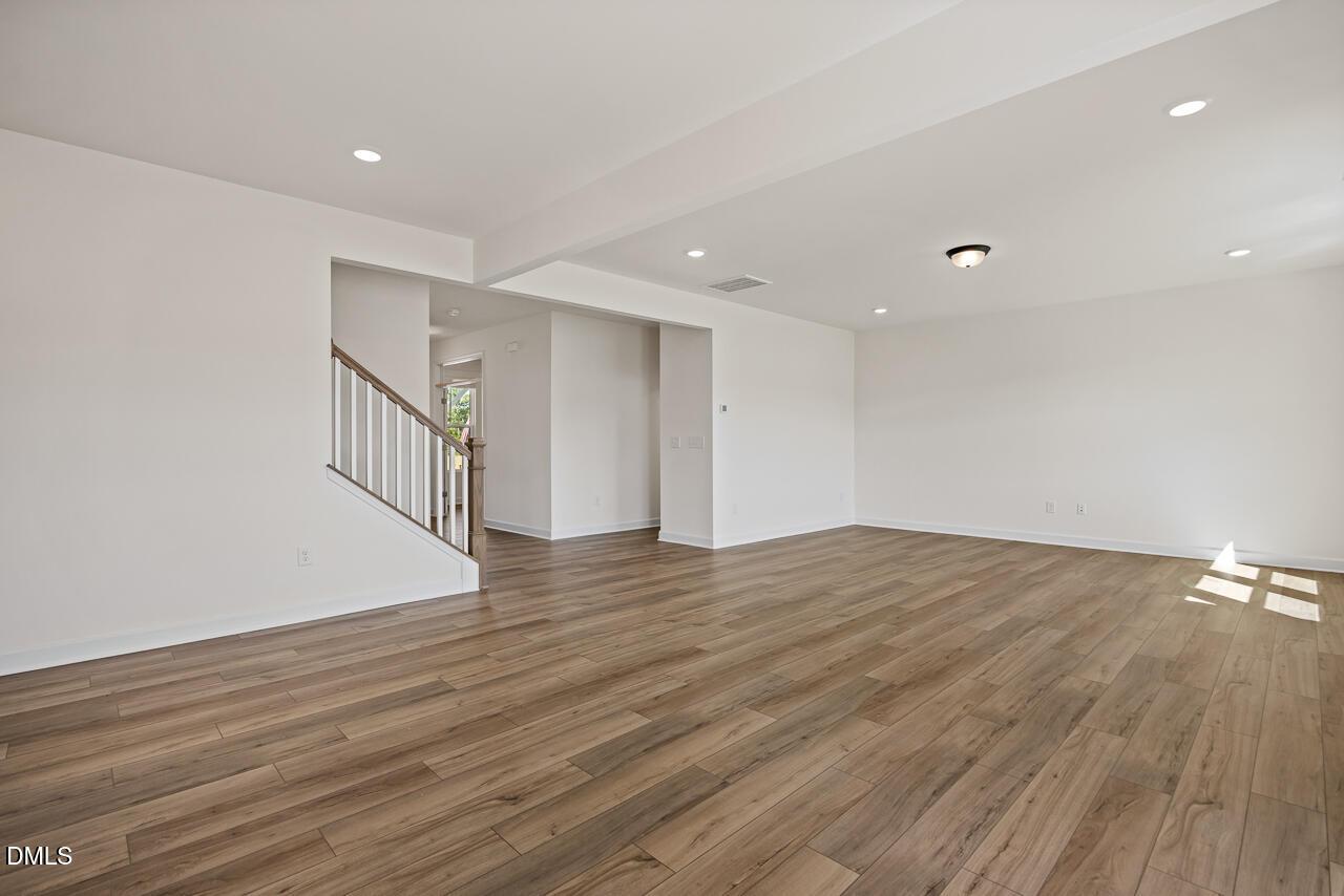 Spacious open-concept living area with luxury vinyl plank flooring and staircase in Davidson Homes Hickory II B, Lillington NC